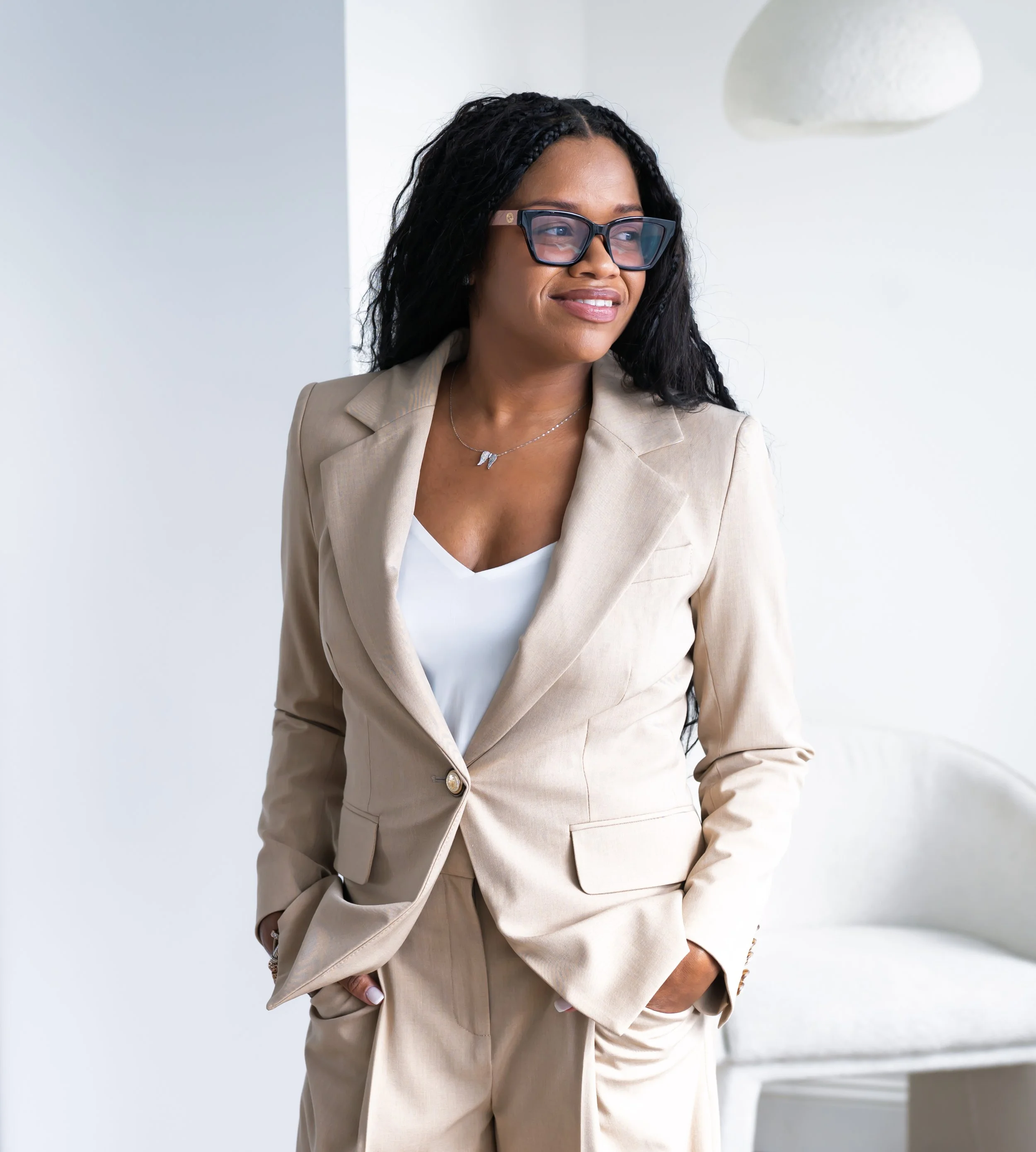 Sowania Germain, LMHC, infertility counselor in West Palm Beach, smiling softly in a tan suit