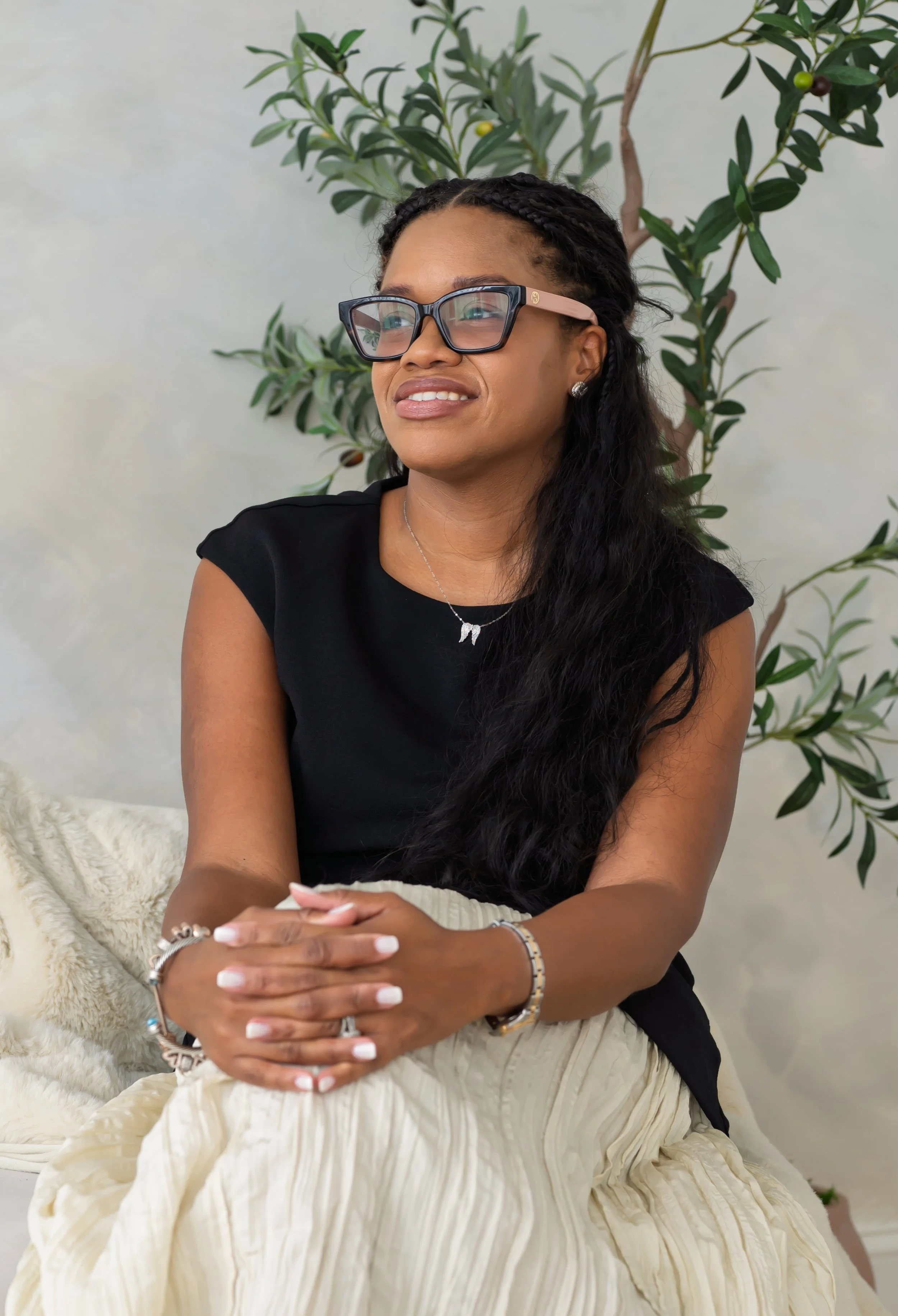 Sowania Germain, LMHC, Christian counselor in West Palm Beach, smiling and gazing upward in a black top