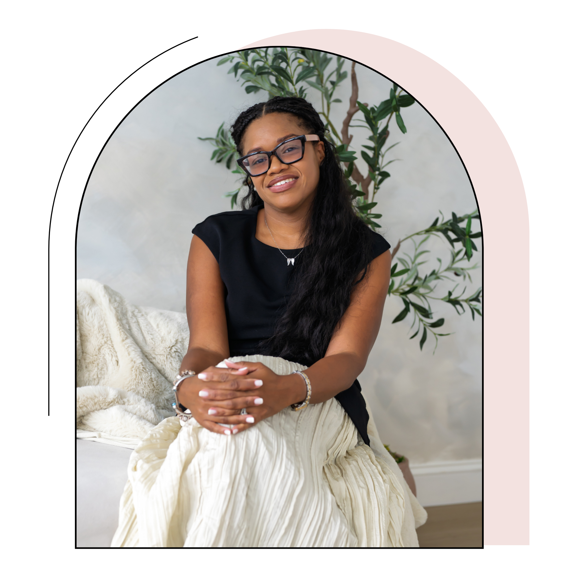 Sowania Germain, LMHC, smiling in a black top and cream skirt, framed by a decorative arch