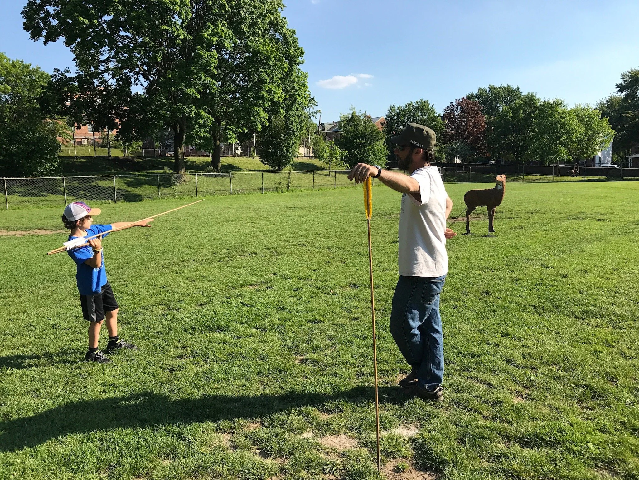 Youth sharpening atlatl skills with target brought by Meadowcroft