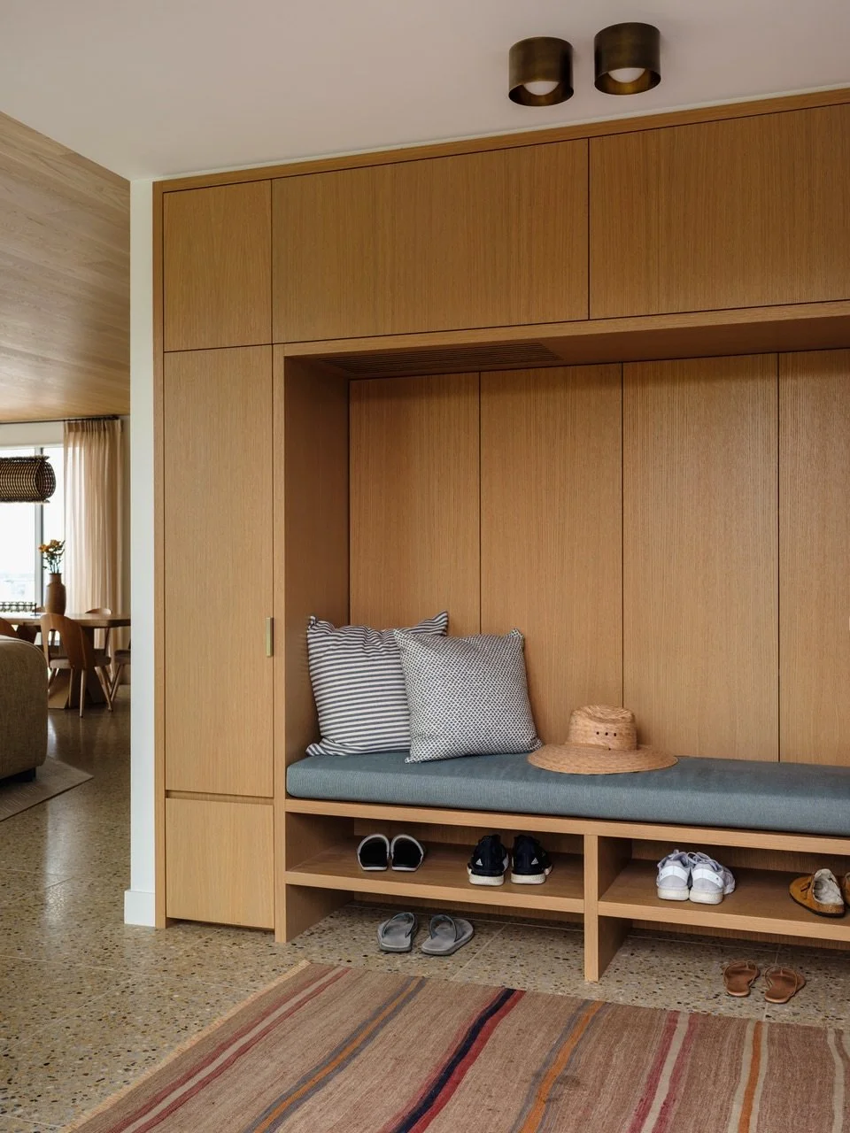 We created a clear entry space where none existed previously, utilizing functional millwork with strategically revealed and concealed storage inside and landscaping and lighting outside to signify the moment of arrival. 

Architecture and interior de