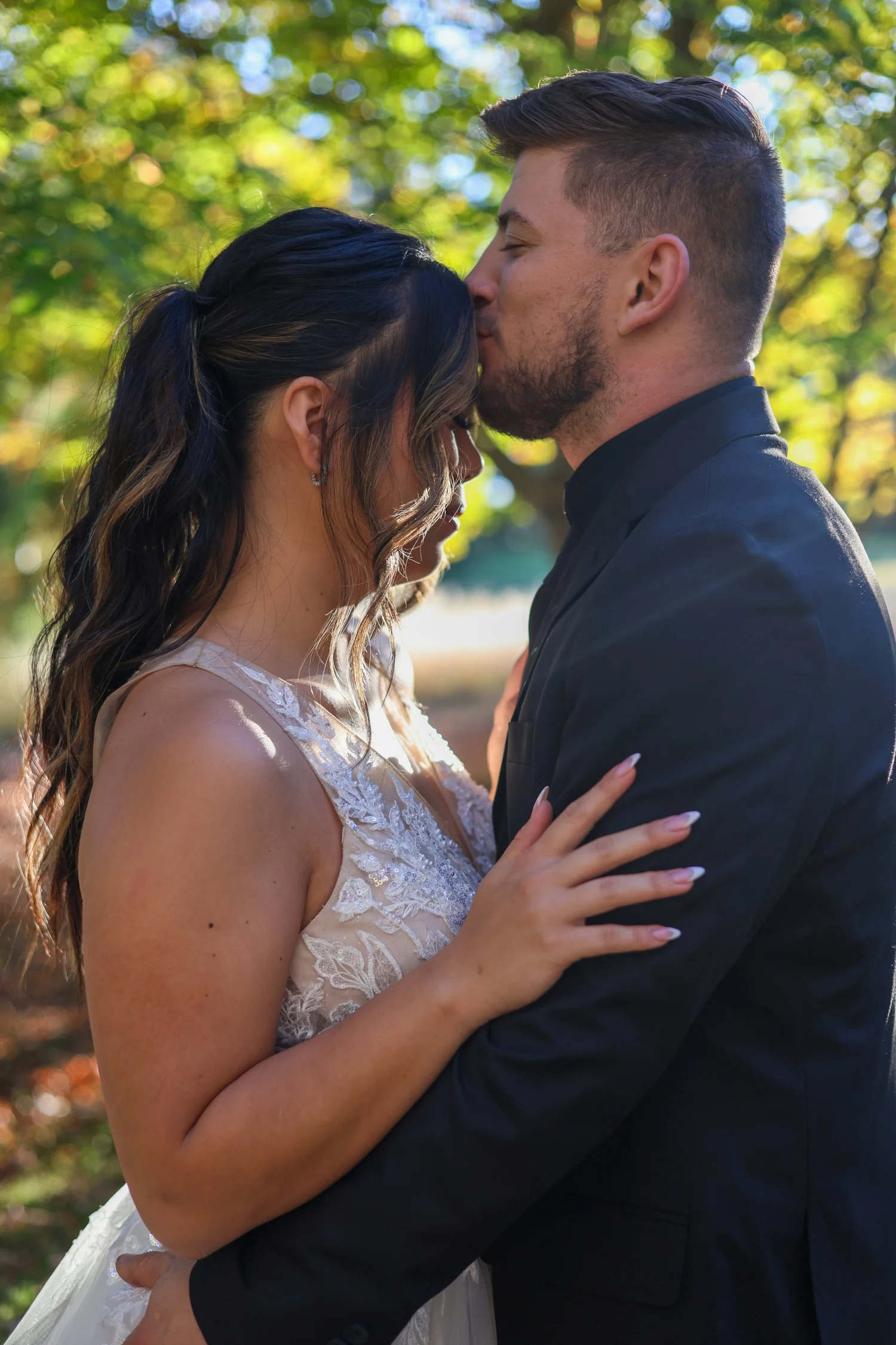 Groom kissing bride on the forehead