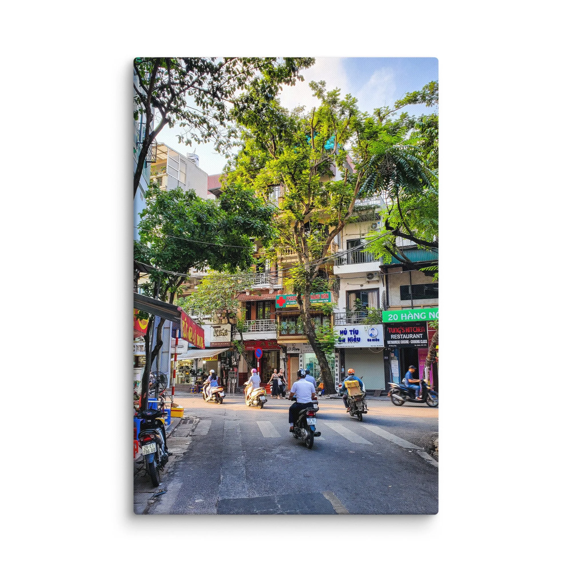 Vibrant Hanoi Old Quarter street with scooters, colonial shophouses, trees and pedestrians – authentic Vietnam travel photography canvas print wall art decor