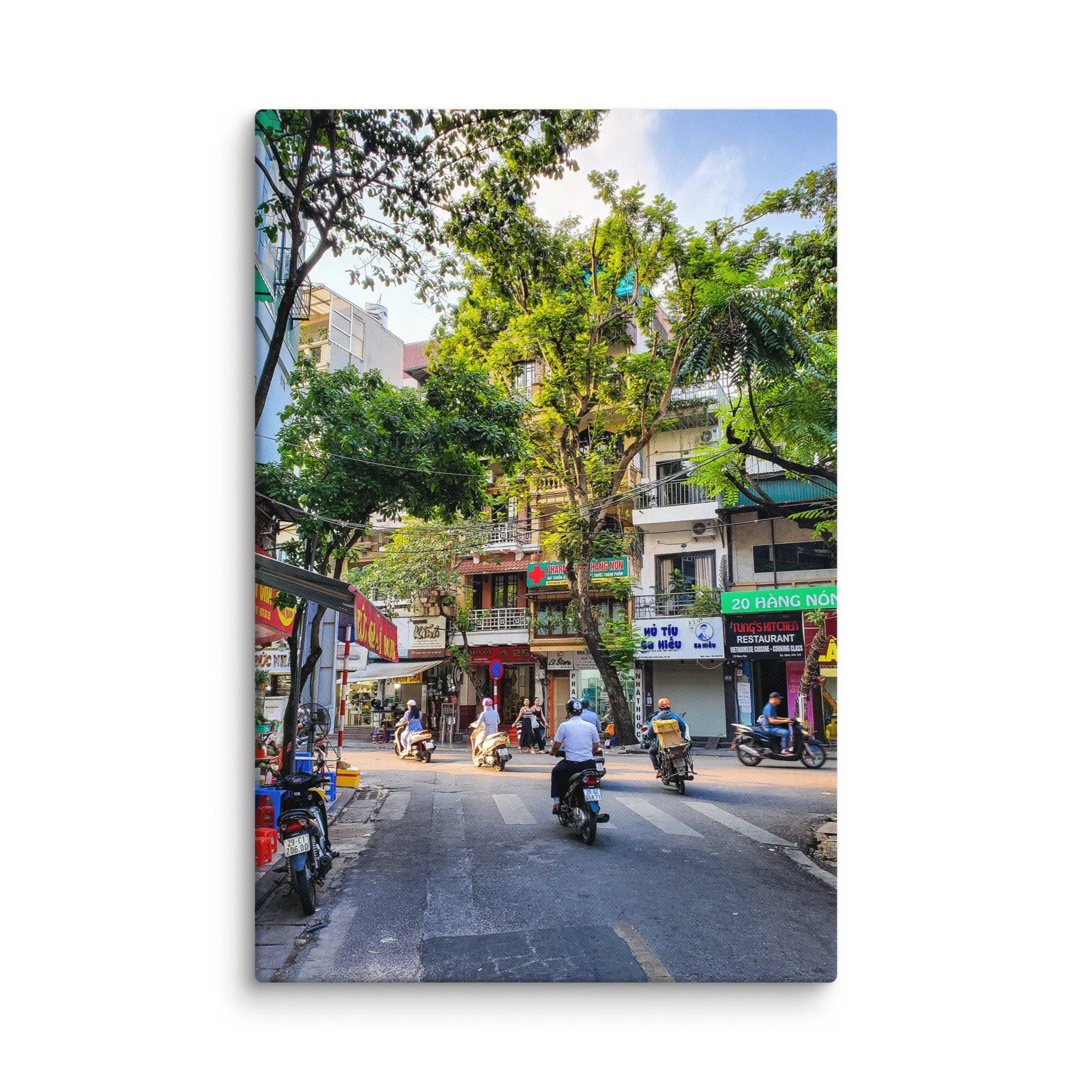 Vibrant Hanoi Old Quarter street with scooters, colonial shophouses, trees and pedestrians – authentic Vietnam travel photography canvas print wall art decor