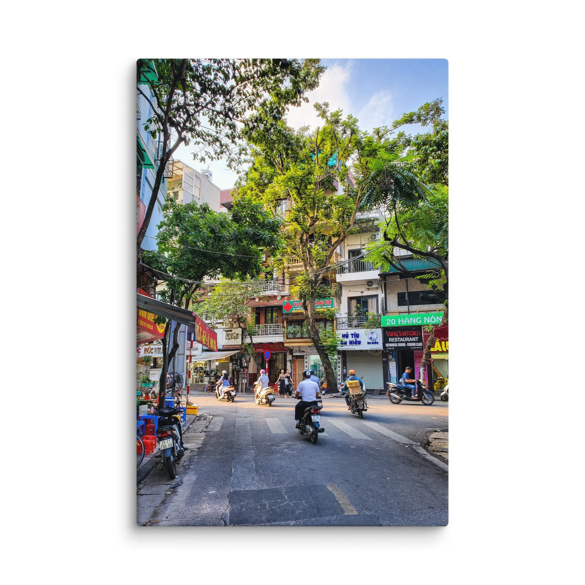 Vibrant Hanoi Old Quarter street with scooters, colonial shophouses, trees and pedestrians – authentic Vietnam travel photography canvas print wall art decor