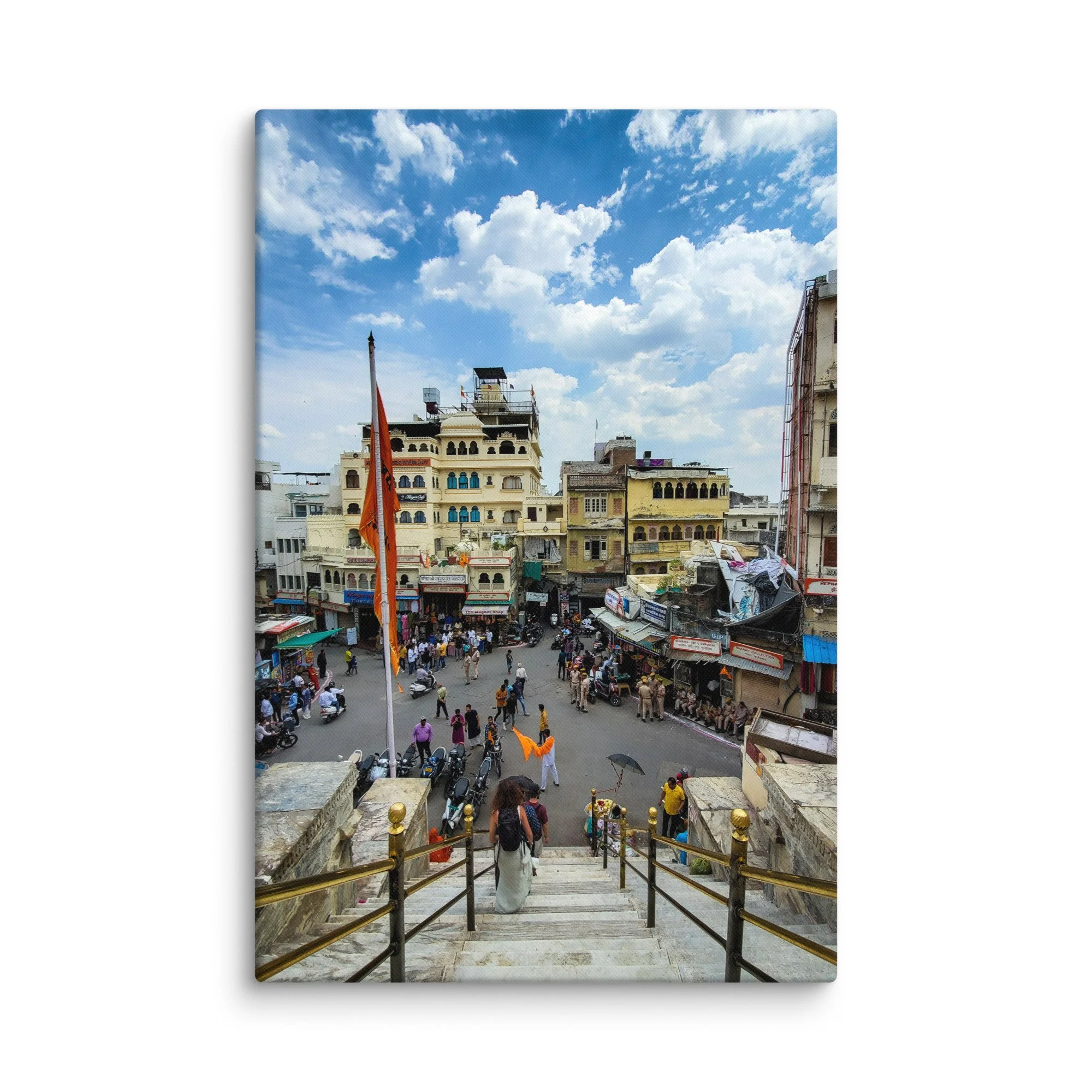 Elevated view of Udaipur temple square with crowds, orange flags, market and colorful buildings – vibrant Rajasthan India travel photography canvas print wall art decor