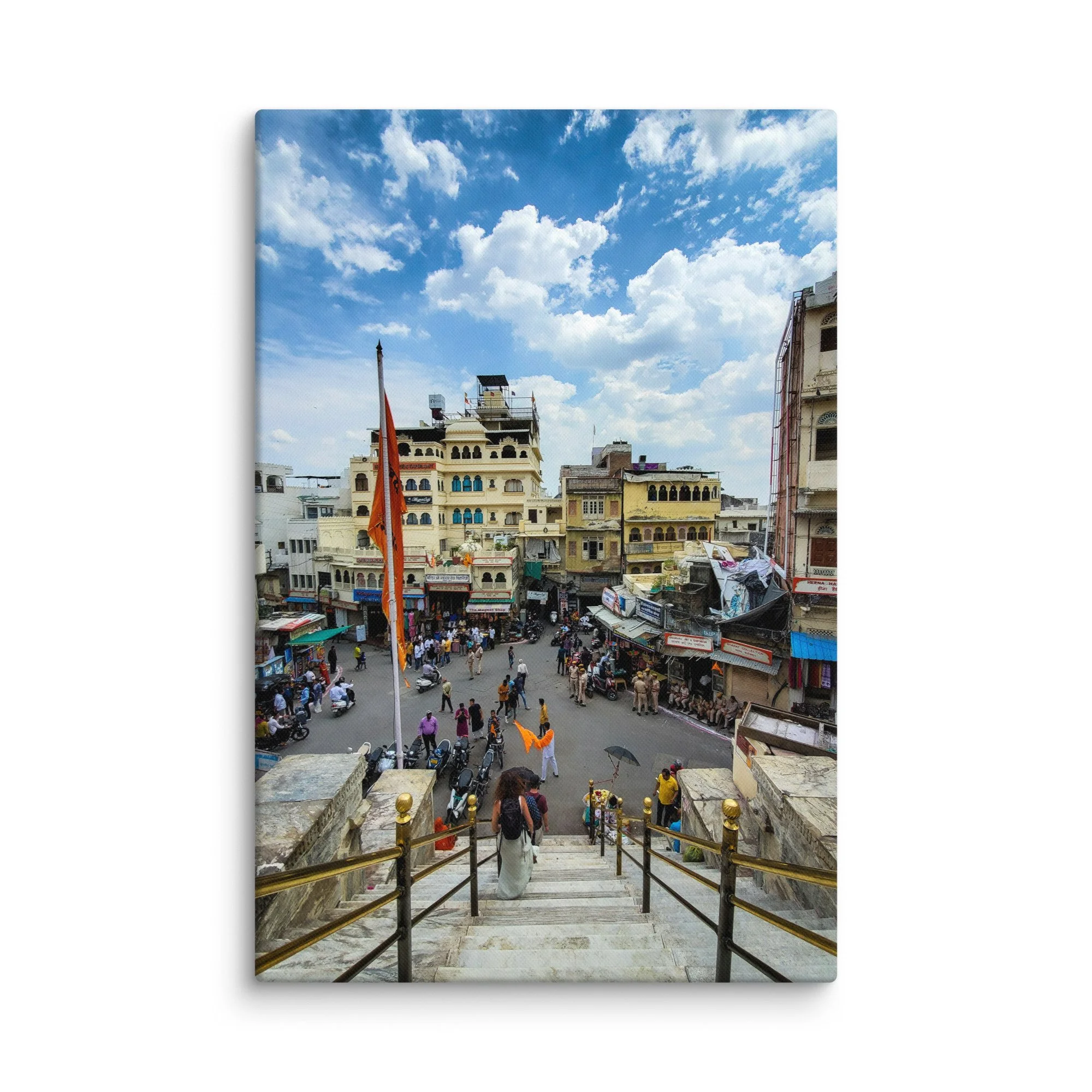 Elevated view of Udaipur temple square with crowds, orange flags, market and colorful buildings – vibrant Rajasthan India travel photography canvas print wall art decor