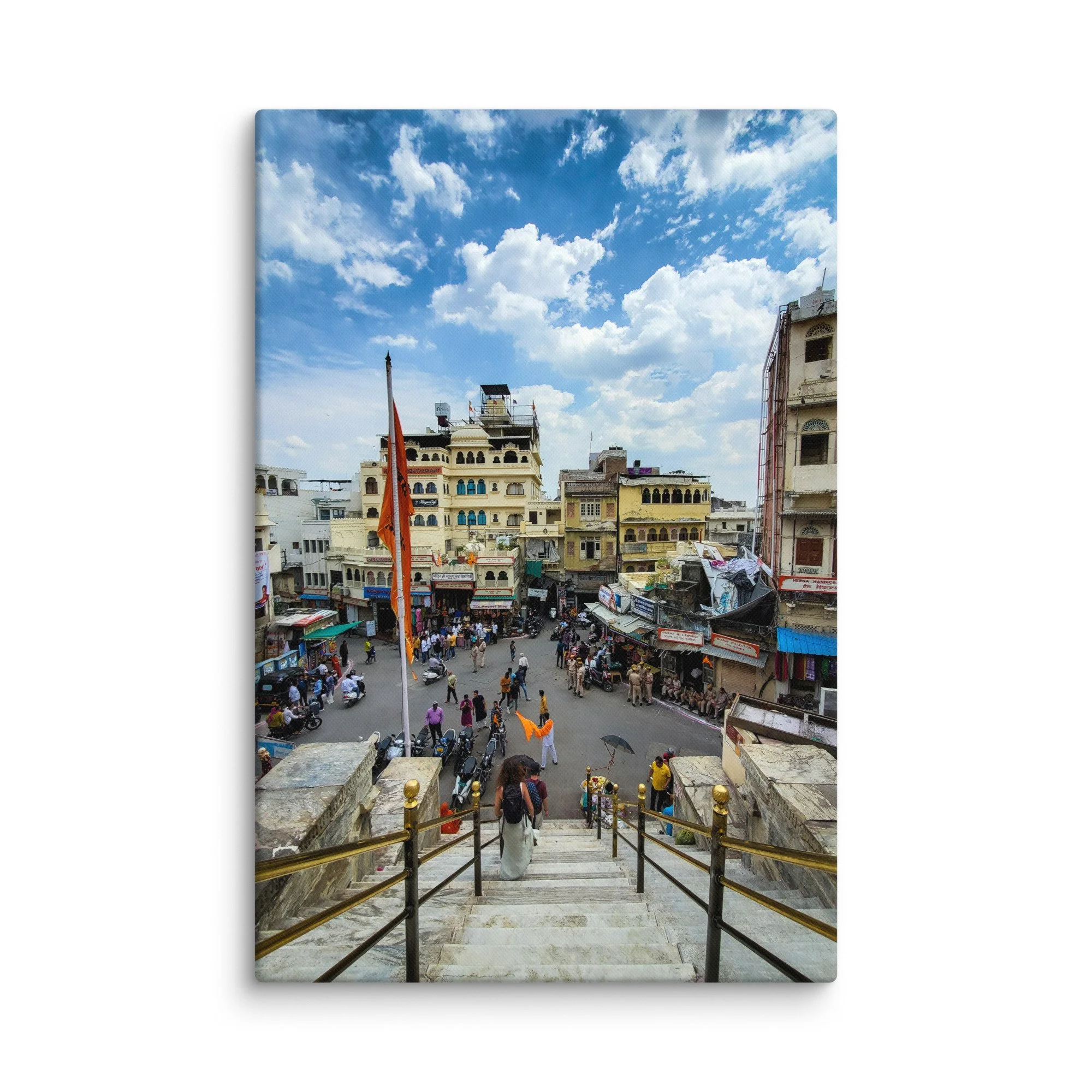 Elevated view of Udaipur temple square with crowds, orange flags, market and colorful buildings – vibrant Rajasthan India travel photography canvas print wall art decor