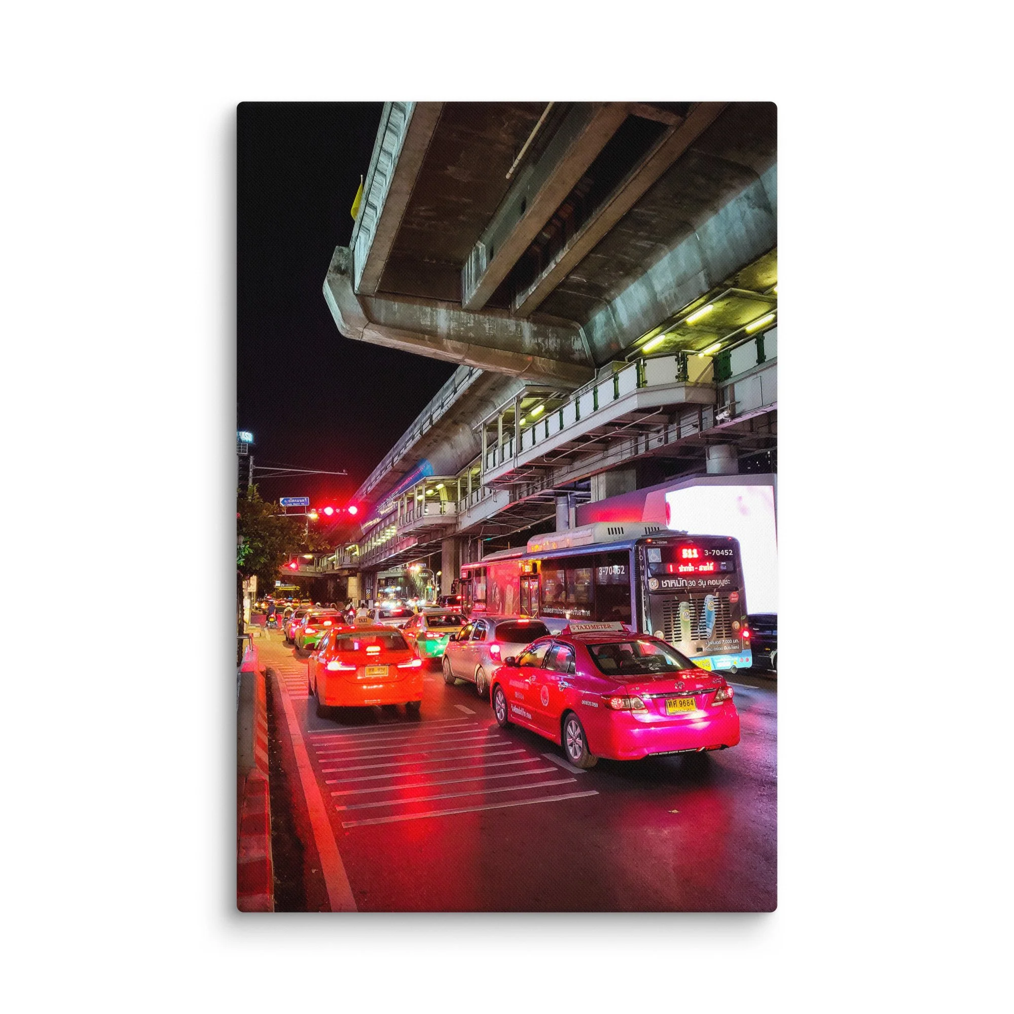 Dramatic nighttime Bangkok street traffic under Skytrain with red taxis, buses and neon reflections – Thailand urban travel photography canvas print wall art decor
