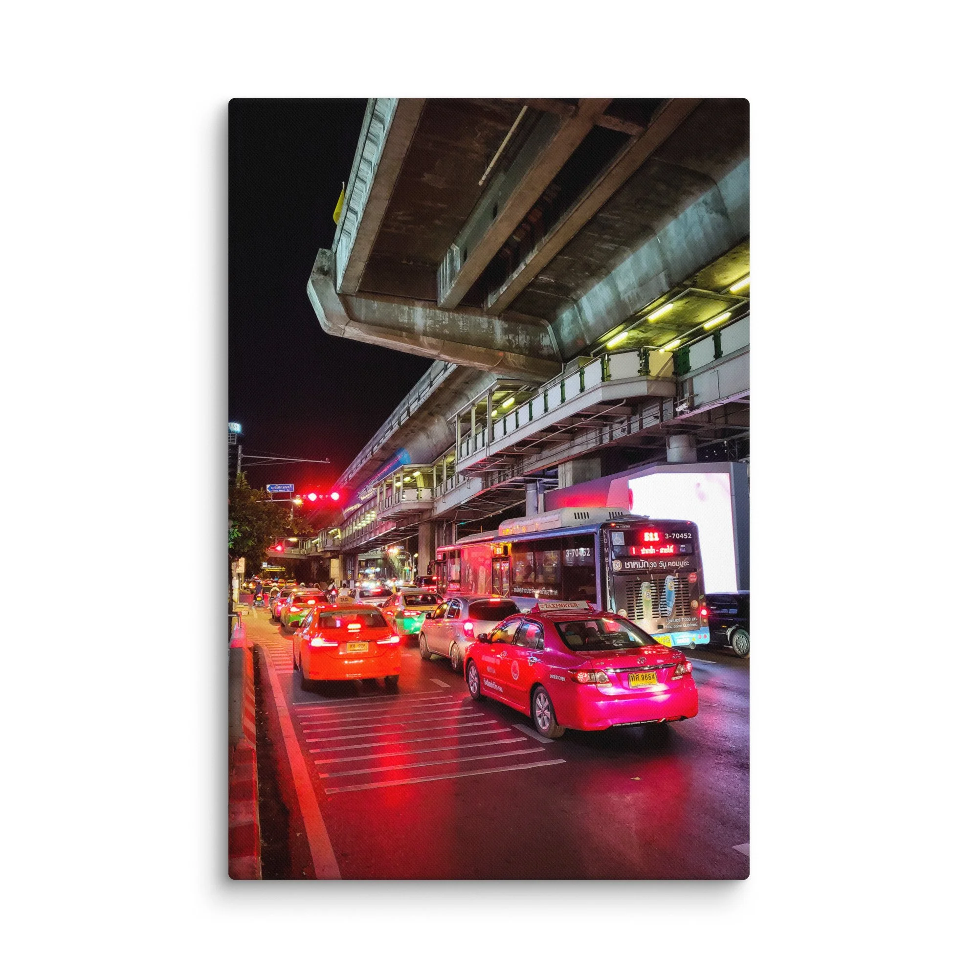 Dramatic nighttime Bangkok street traffic under Skytrain with red taxis, buses and neon reflections – Thailand urban travel photography canvas print wall art decor