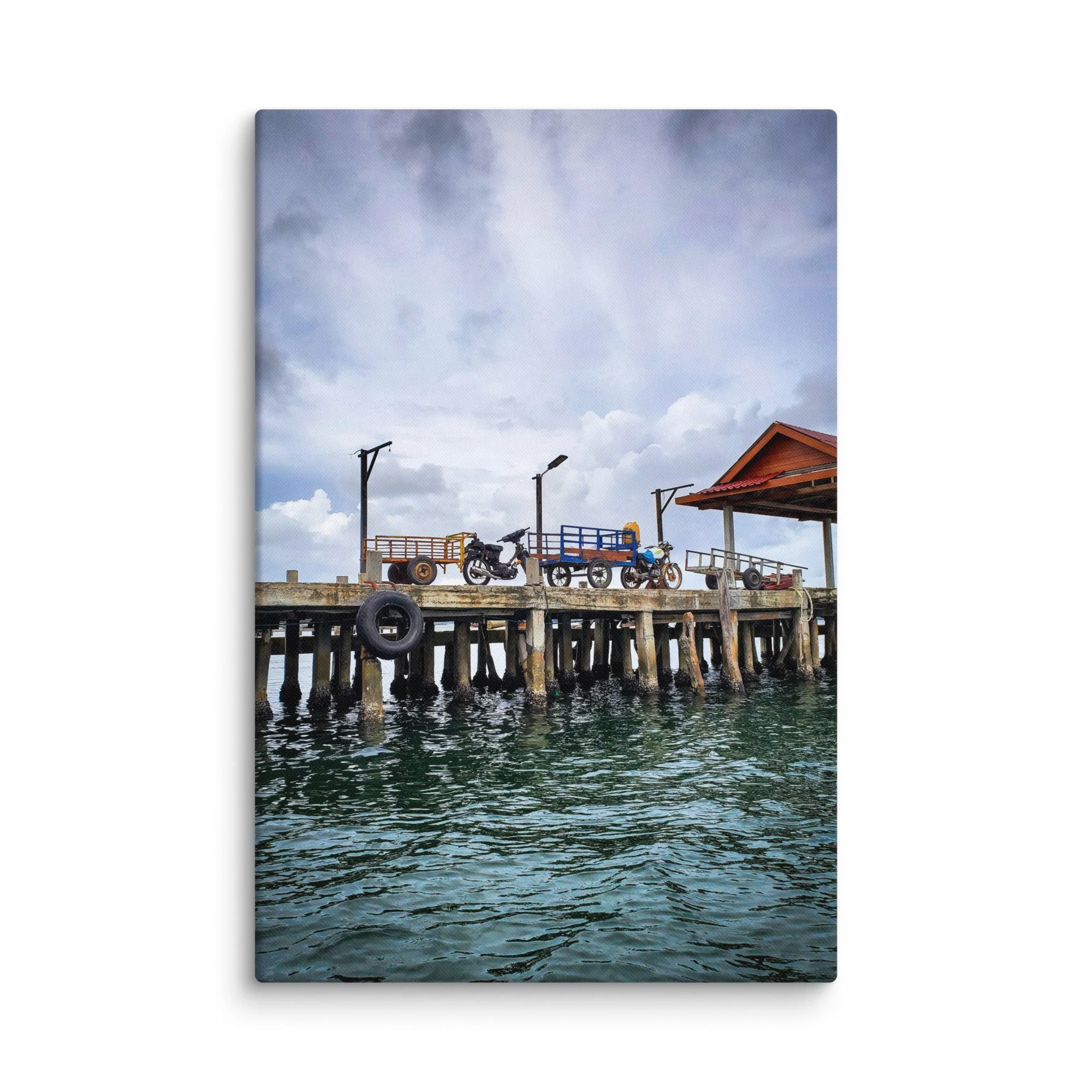 Authentic Koh Rong island wooden pier with scooters, cargo carts and calm green water under overcast sky – Cambodia travel photography canvas print wall art decor