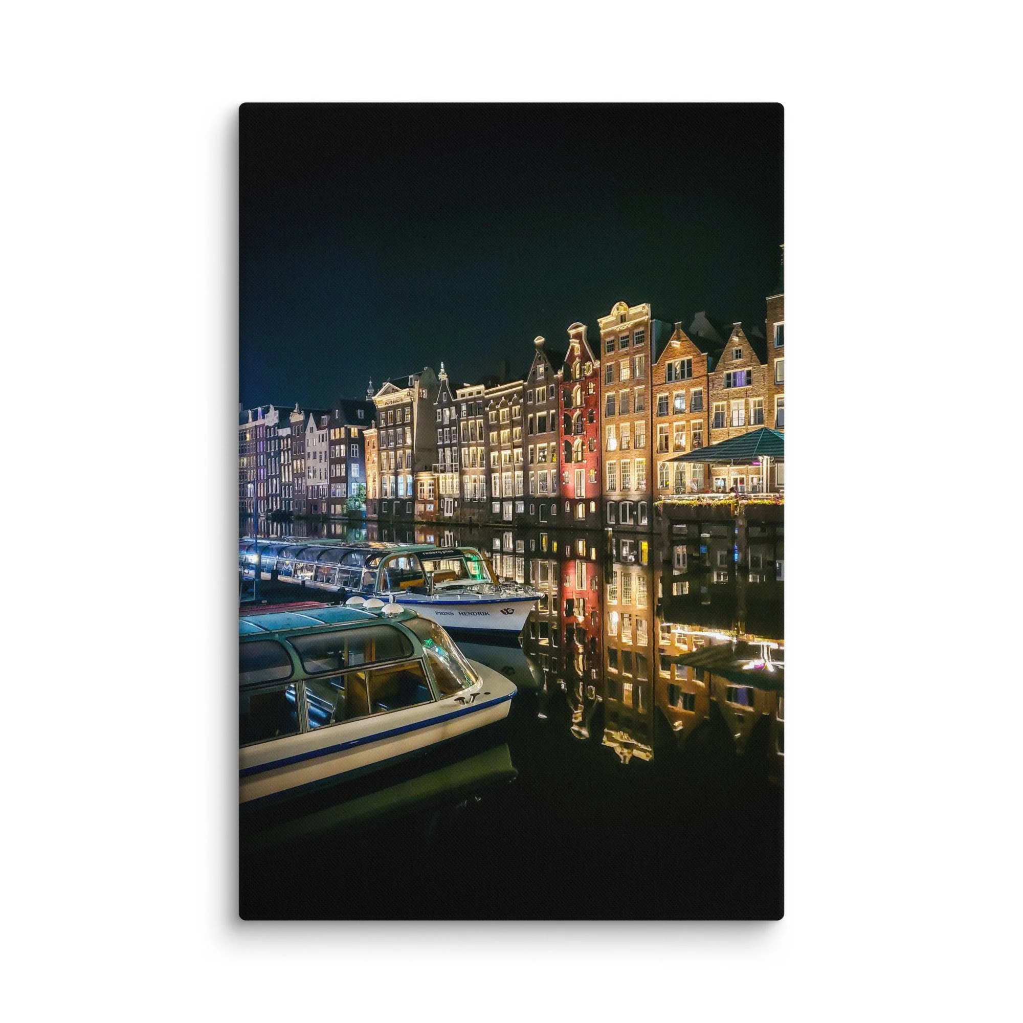 Romantic nighttime Amsterdam canal with illuminated gabled houses reflecting in water and docked Prins Hendrik boat – Netherlands city travel photography canvas print wall art decor