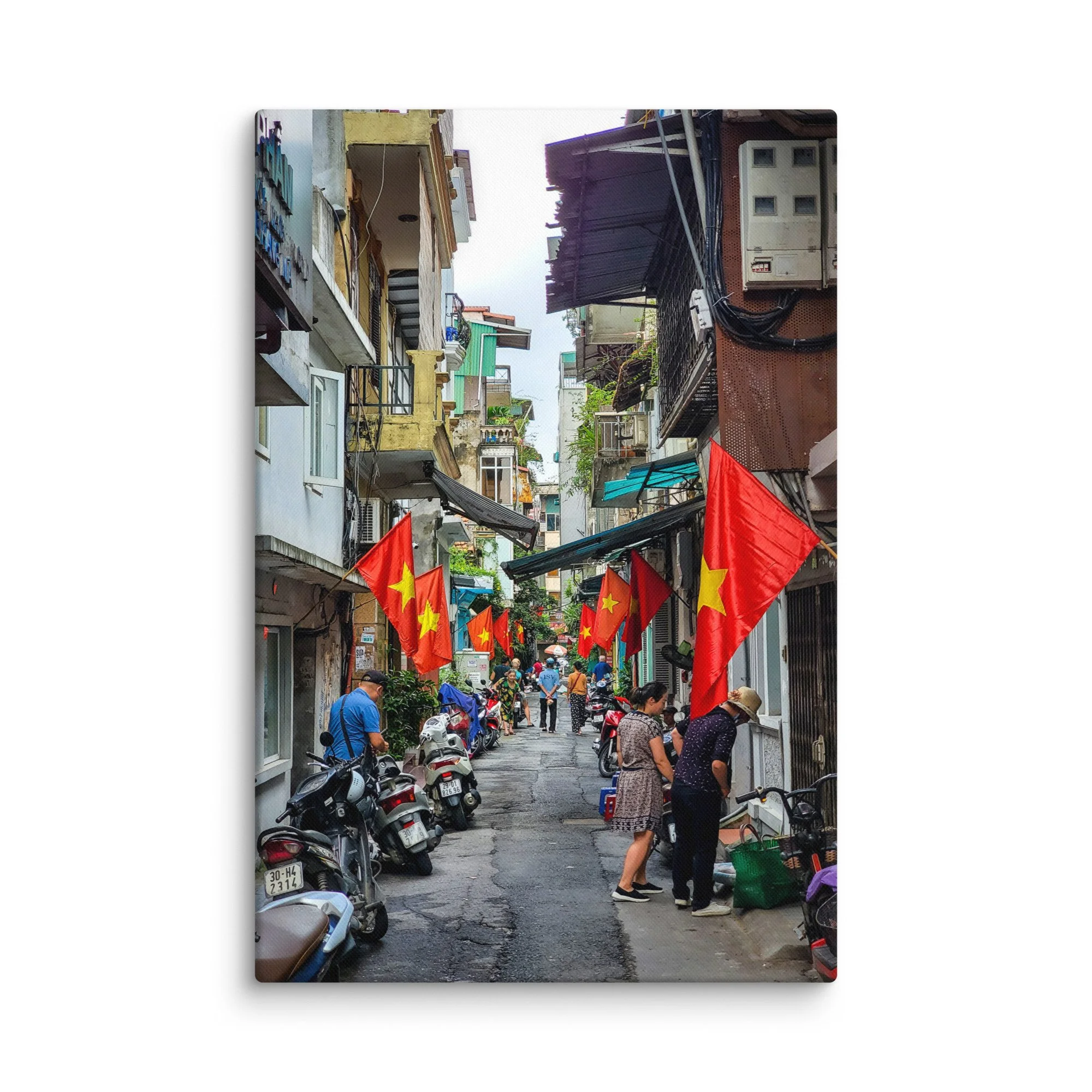 Vibrant Hanoi Old Quarter narrow alley with red Vietnamese flags, colorful buildings, scooters and locals – authentic Vietnam travel photography canvas print wall art decor