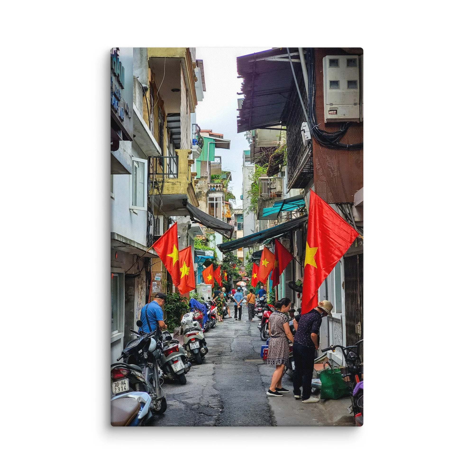 Vibrant Hanoi Old Quarter narrow alley with red Vietnamese flags, colorful buildings, scooters and locals – authentic Vietnam travel photography canvas print wall art decor