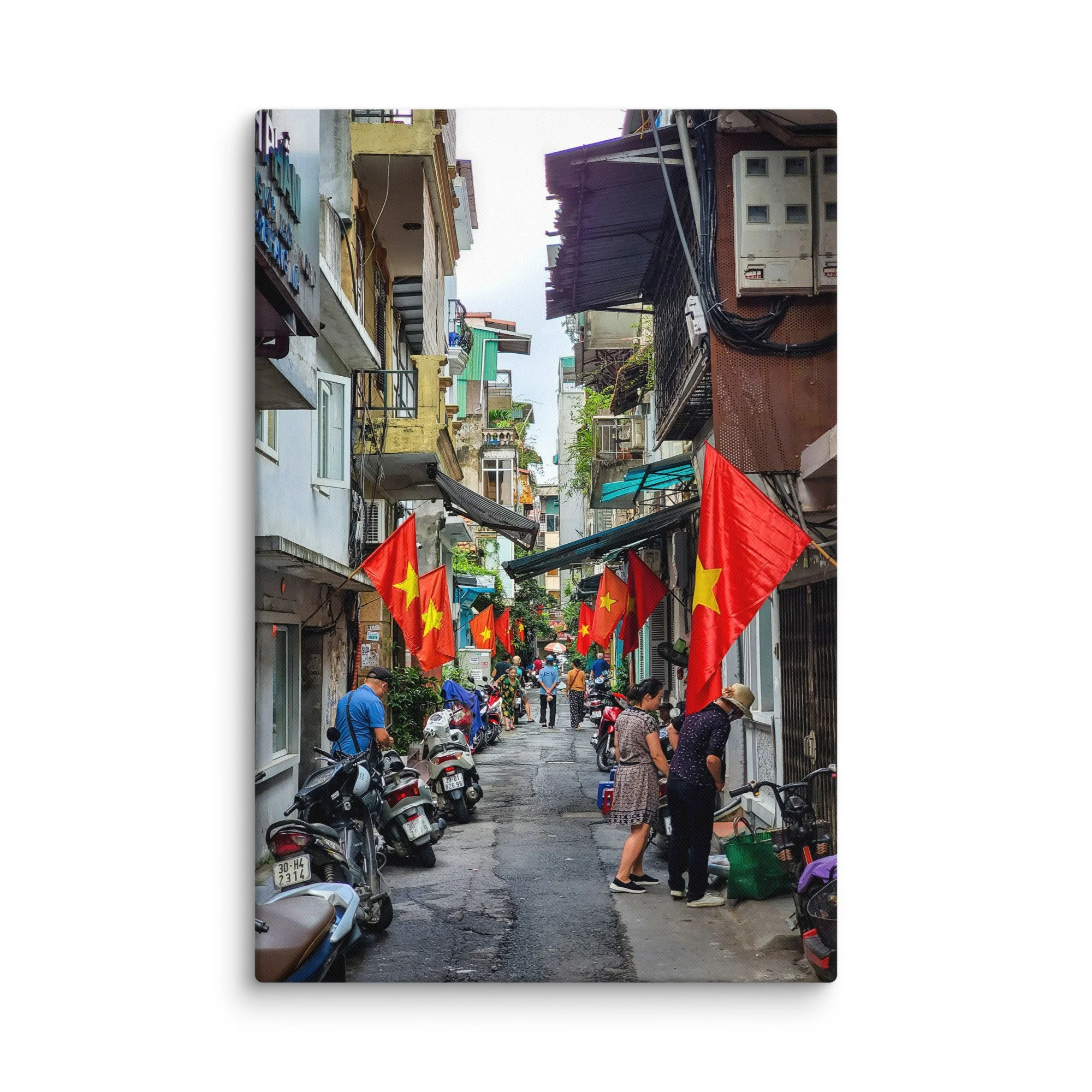 Vibrant Hanoi Old Quarter narrow alley with red Vietnamese flags, colorful buildings, scooters and locals – authentic Vietnam travel photography canvas print wall art decor