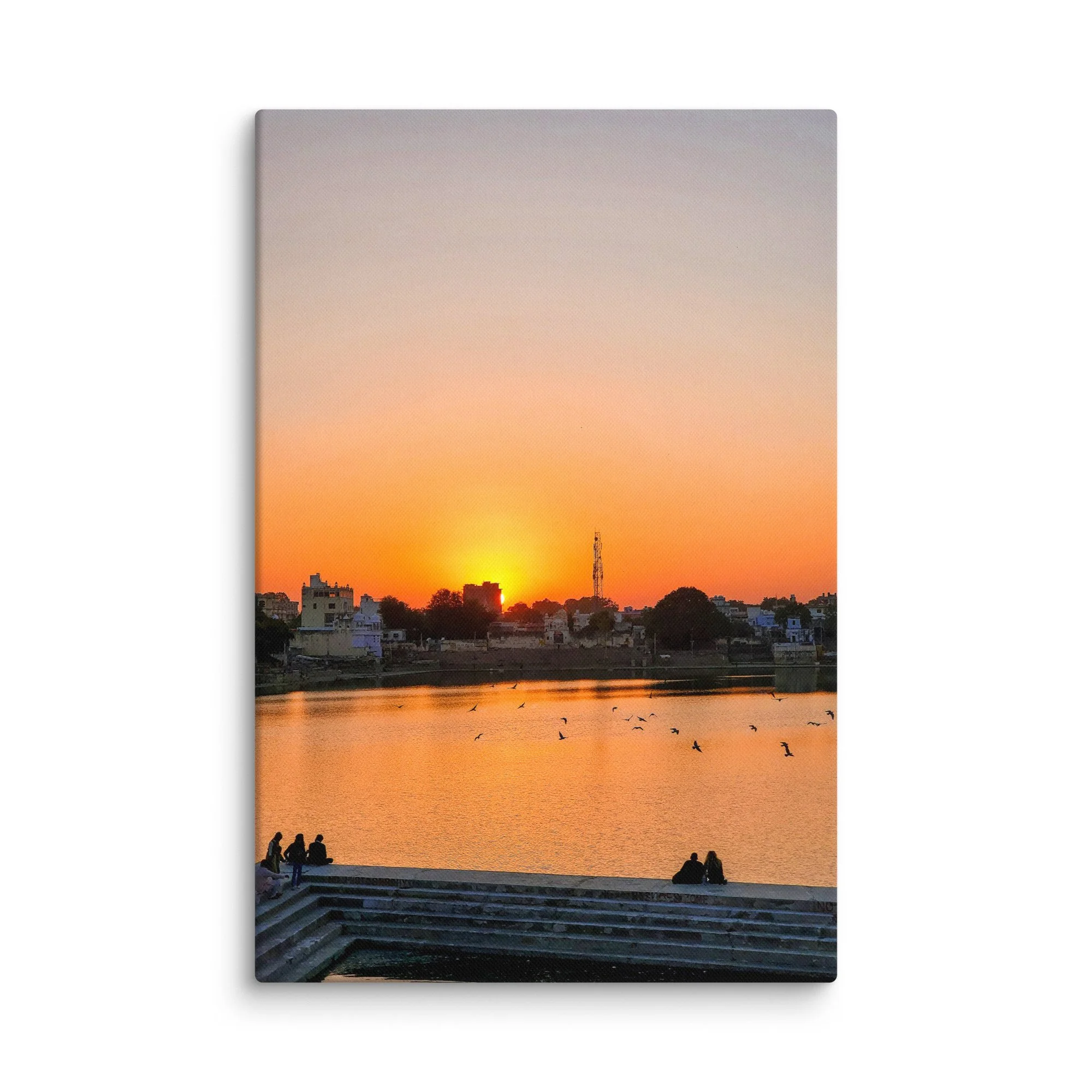 Serene sunset over Pushkar Lake with pilgrims on ghats, birds flying and warm orange sky reflection – sacred Rajasthan India travel photography canvas print wall art decor