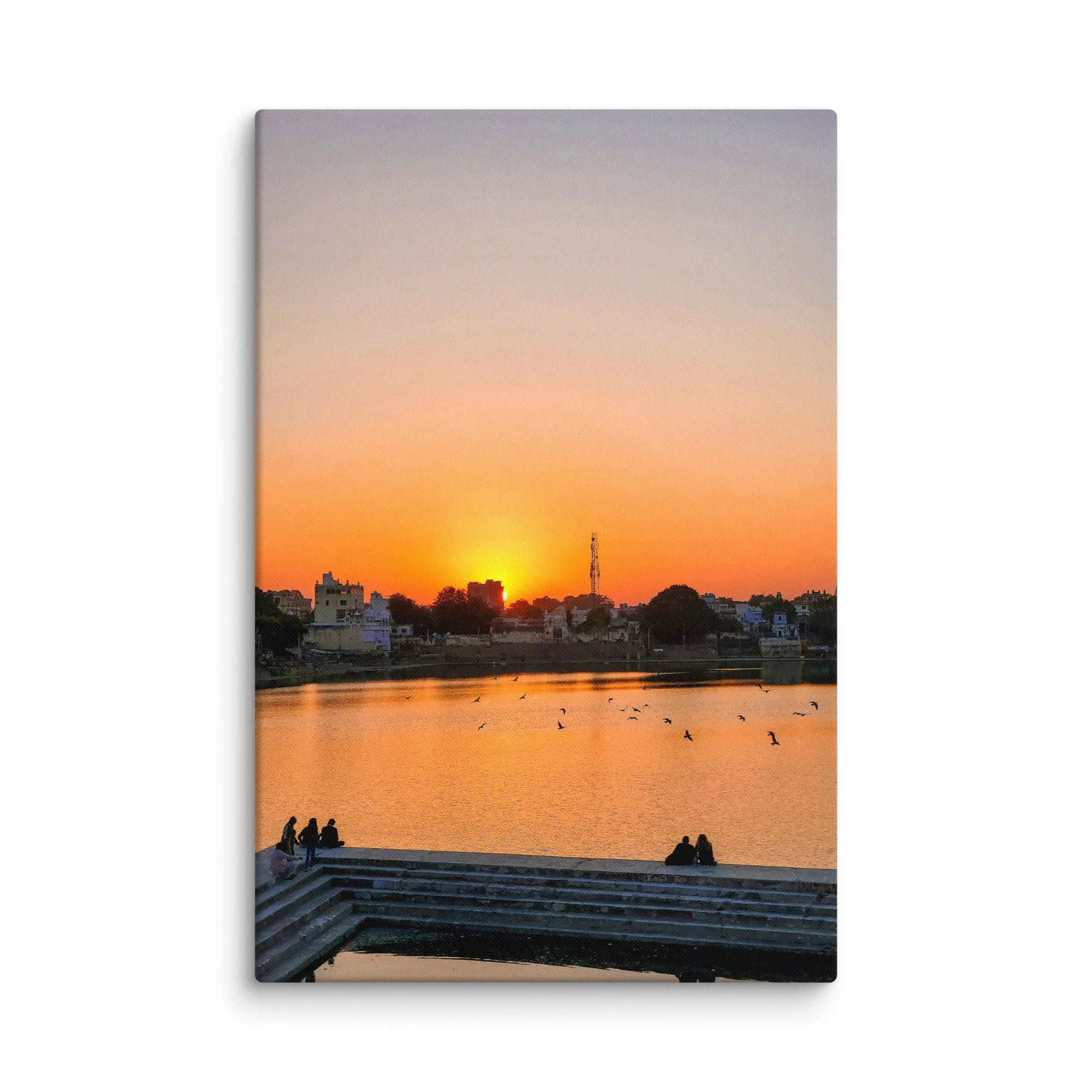 Serene sunset over Pushkar Lake with pilgrims on ghats, birds flying and warm orange sky reflection – sacred Rajasthan India travel photography canvas print wall art decor