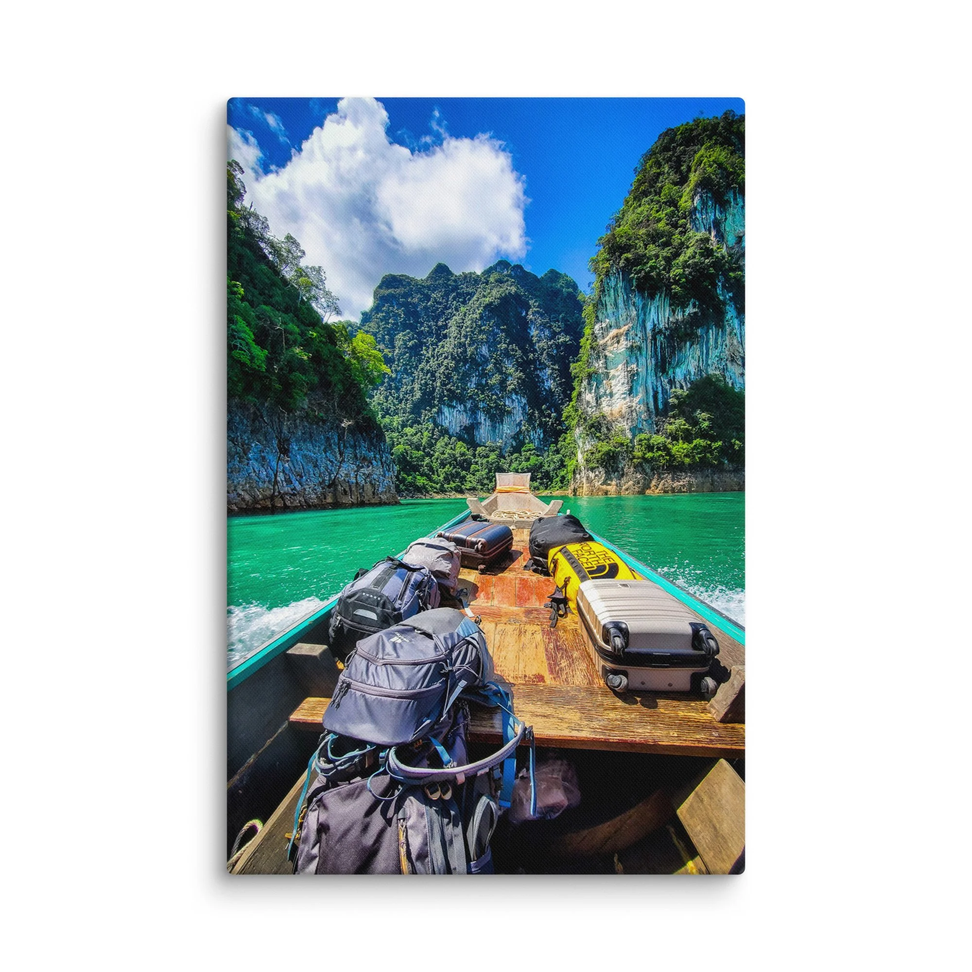 Longtail boat with backpacks gliding through turquoise Cheow Lan Lake in Khao Sok National Park, surrounded by limestone karsts and jungle
