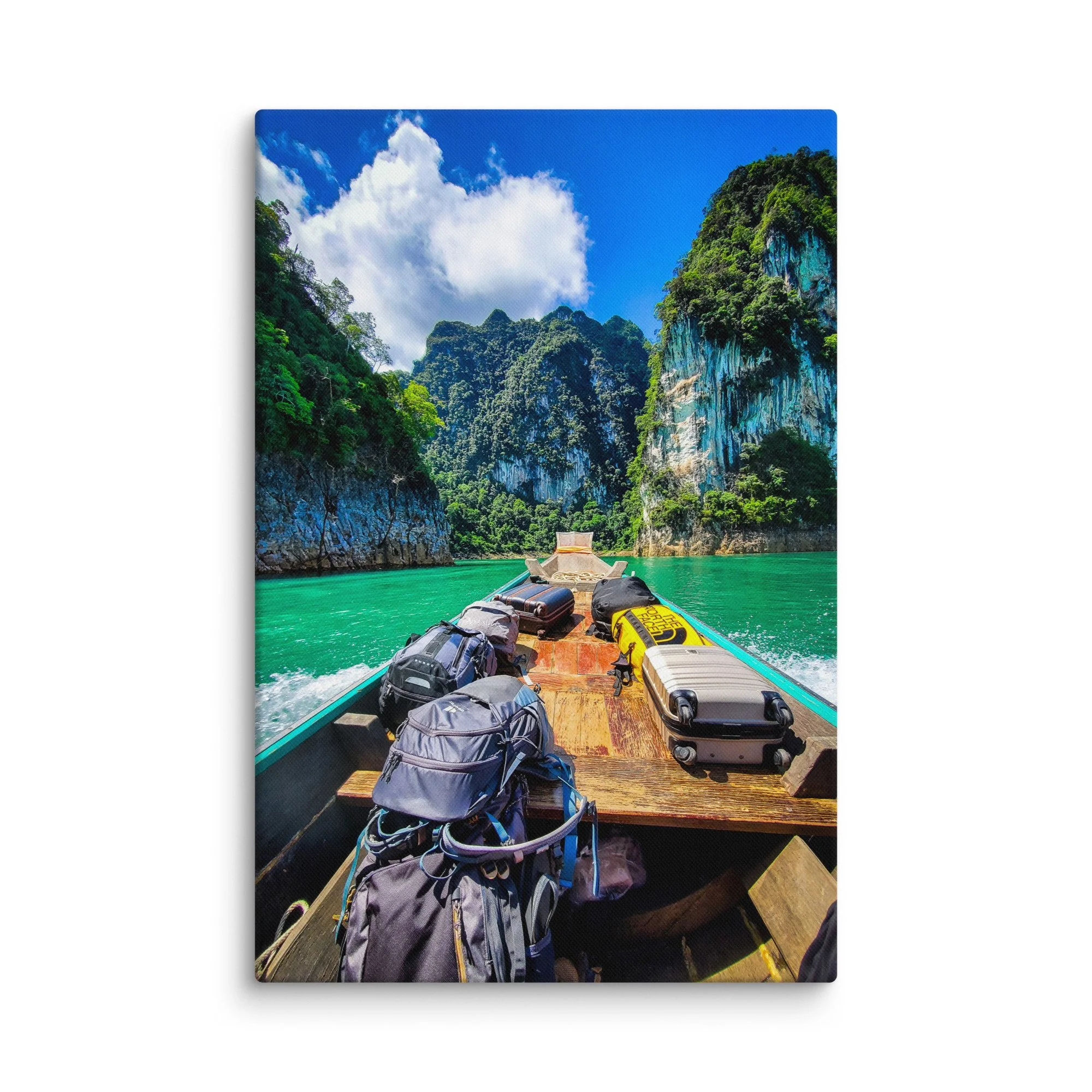 Longtail boat with backpacks gliding through turquoise Cheow Lan Lake in Khao Sok National Park, surrounded by limestone karsts and jungle