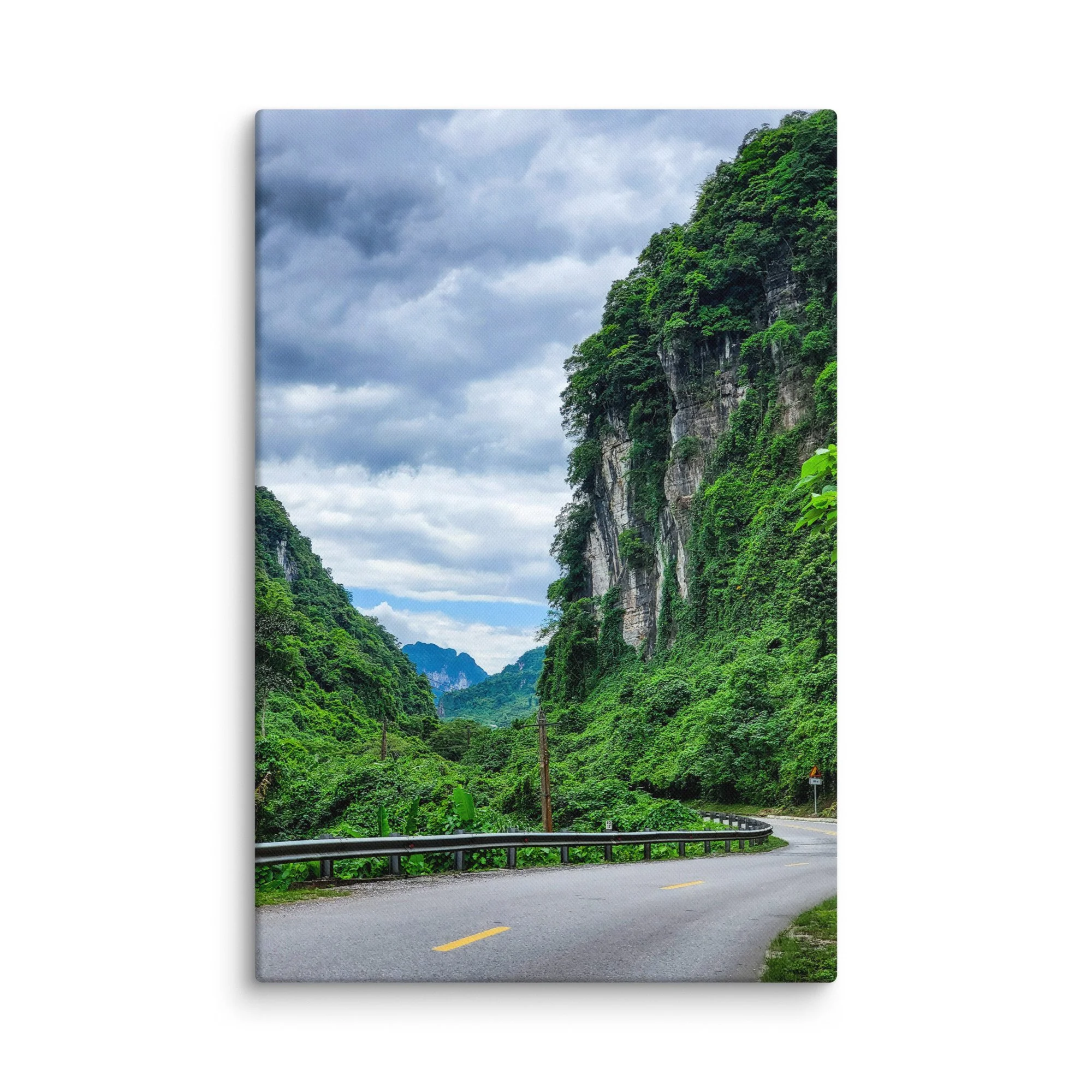 Scenic winding road through lush green karst cliffs and jungle in northern Vietnam (Hà Giang) under cloudy sky – adventure travel photography canvas print wall art decor