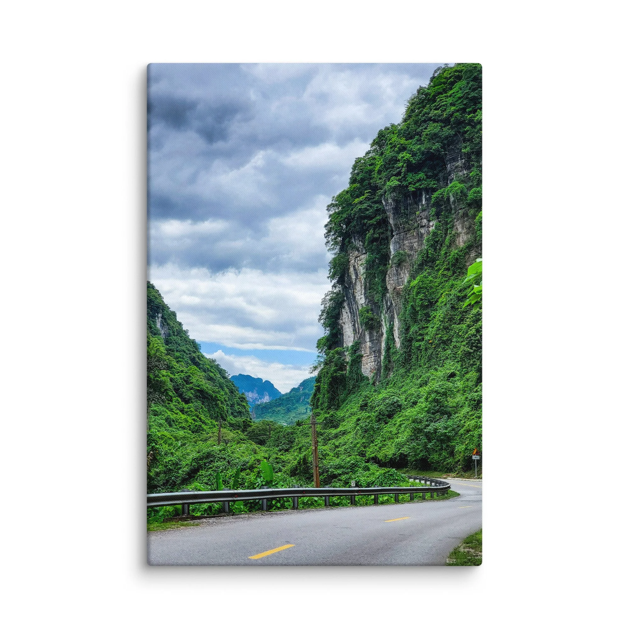 Scenic winding road through lush green karst cliffs and jungle in northern Vietnam (Hà Giang) under cloudy sky – adventure travel photography canvas print wall art decor