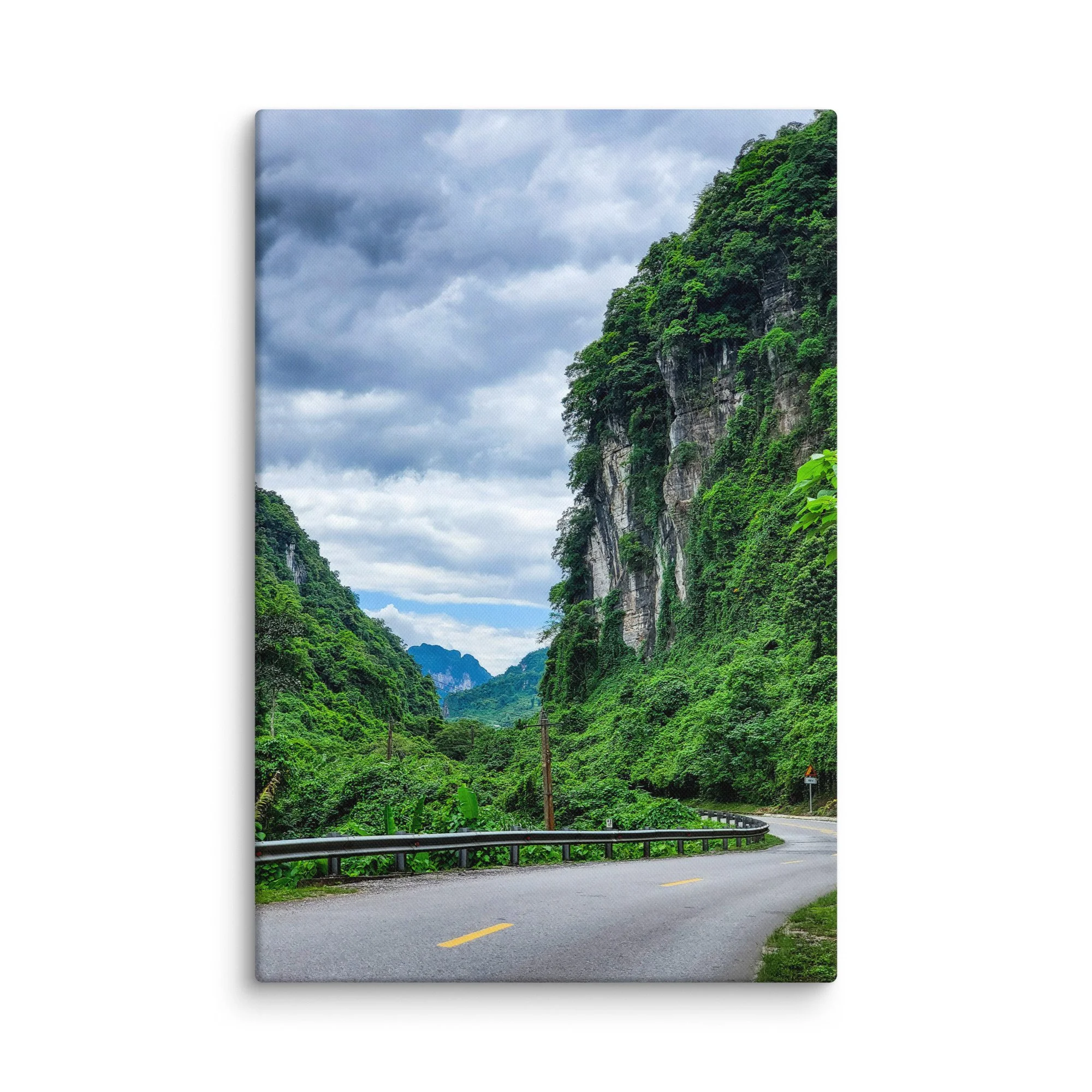 Scenic winding road through lush green karst cliffs and jungle in northern Vietnam (Hà Giang) under cloudy sky – adventure travel photography canvas print wall art decor