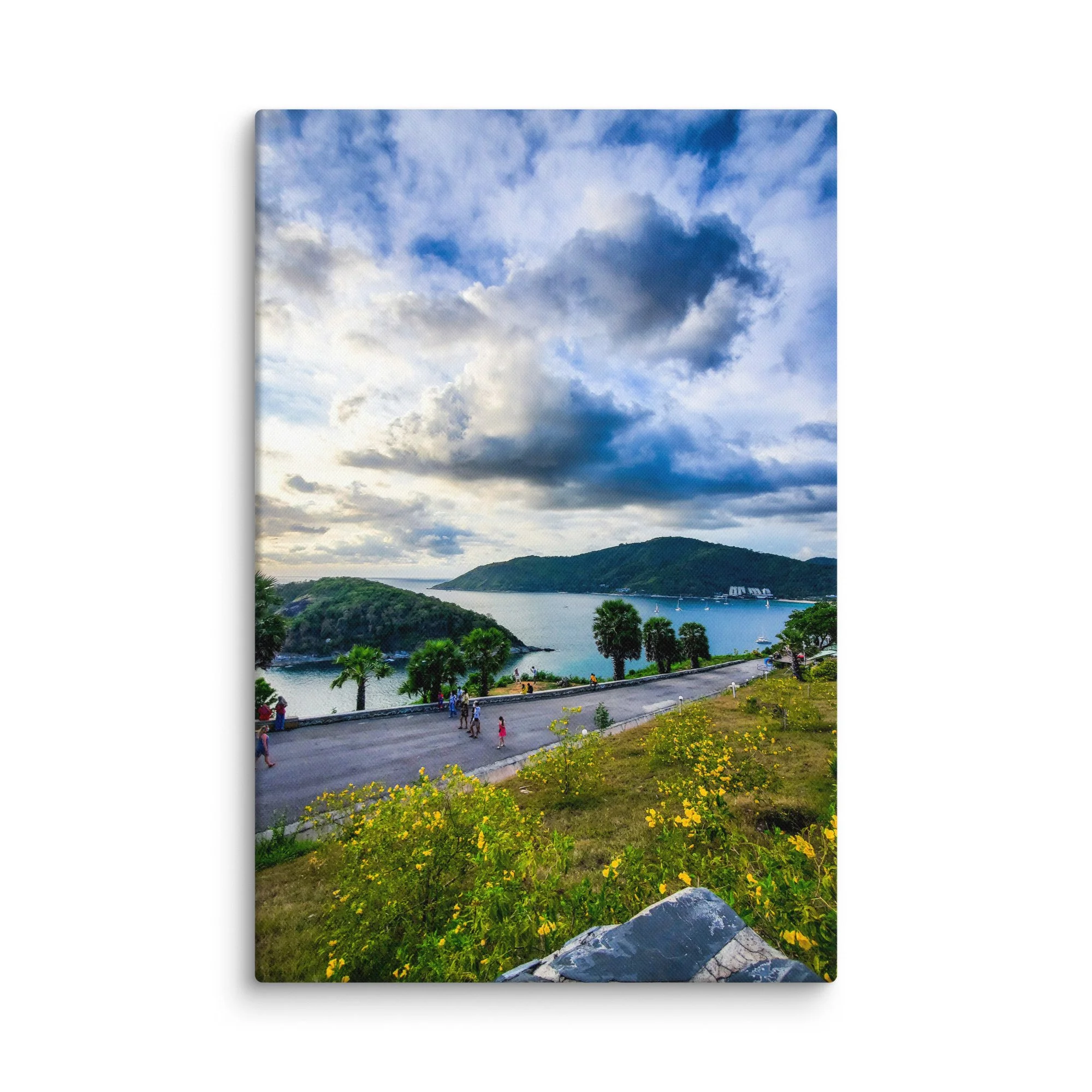 Panoramic sunset view over turquoise bay and islands from Karon Viewpoint in Phuket, Thailand with coastal road and yellow flowers