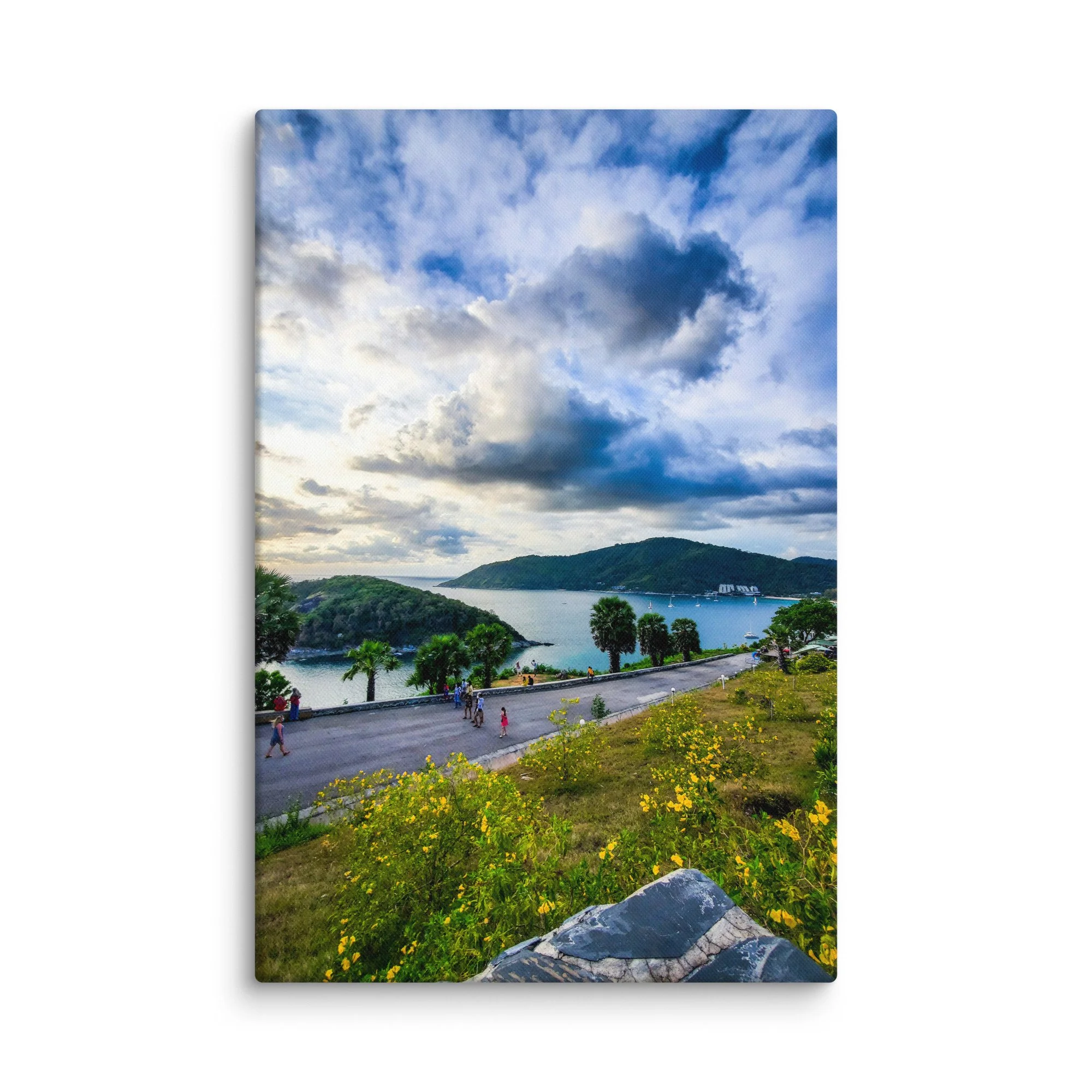 Panoramic sunset view over turquoise bay and islands from Karon Viewpoint in Phuket, Thailand with coastal road and yellow flowers