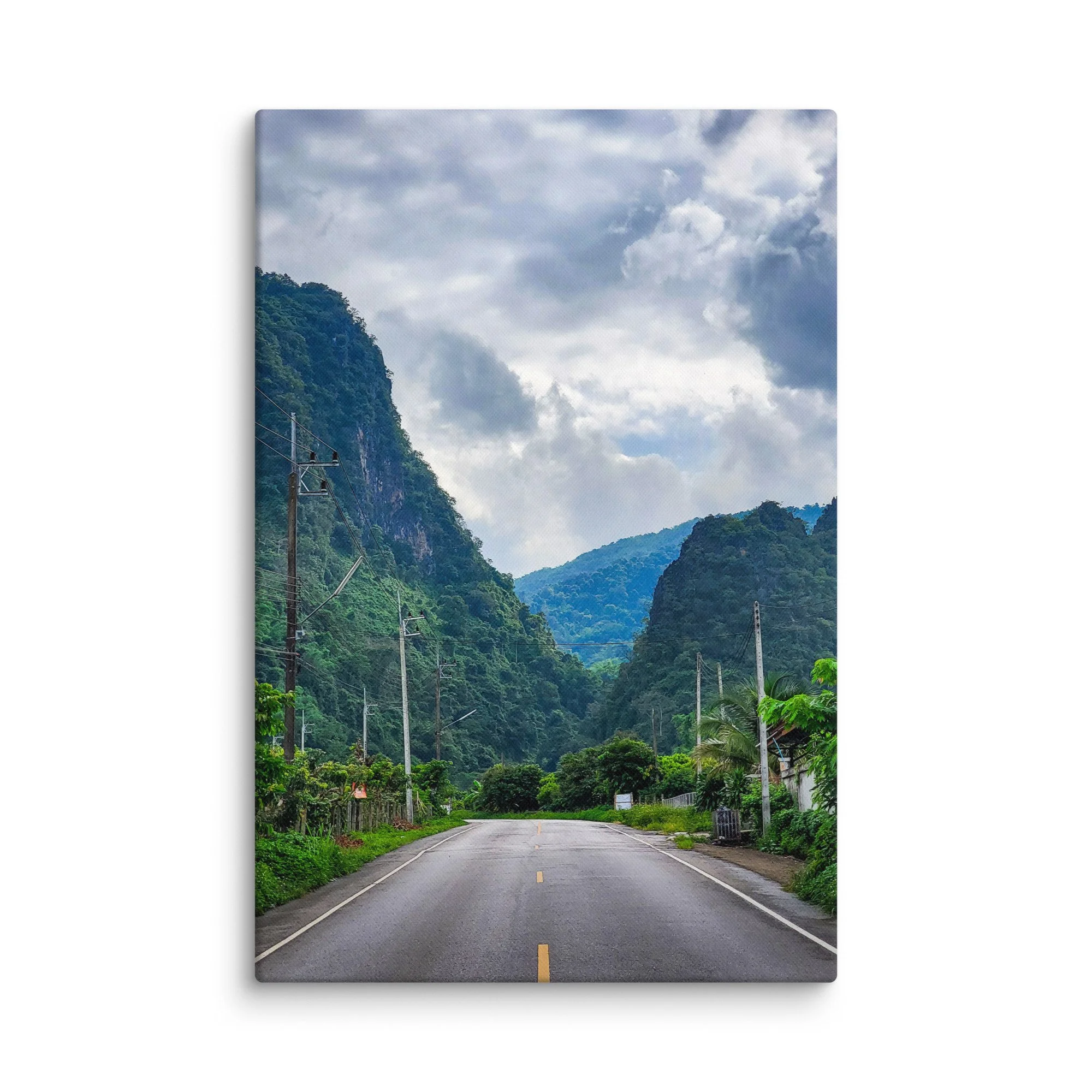 Scenic winding road through lush green karst cliffs and jungle in northern Vietnam (Hà Giang) under dramatic cloudy sky – adventure travel photography canvas print wall art decor