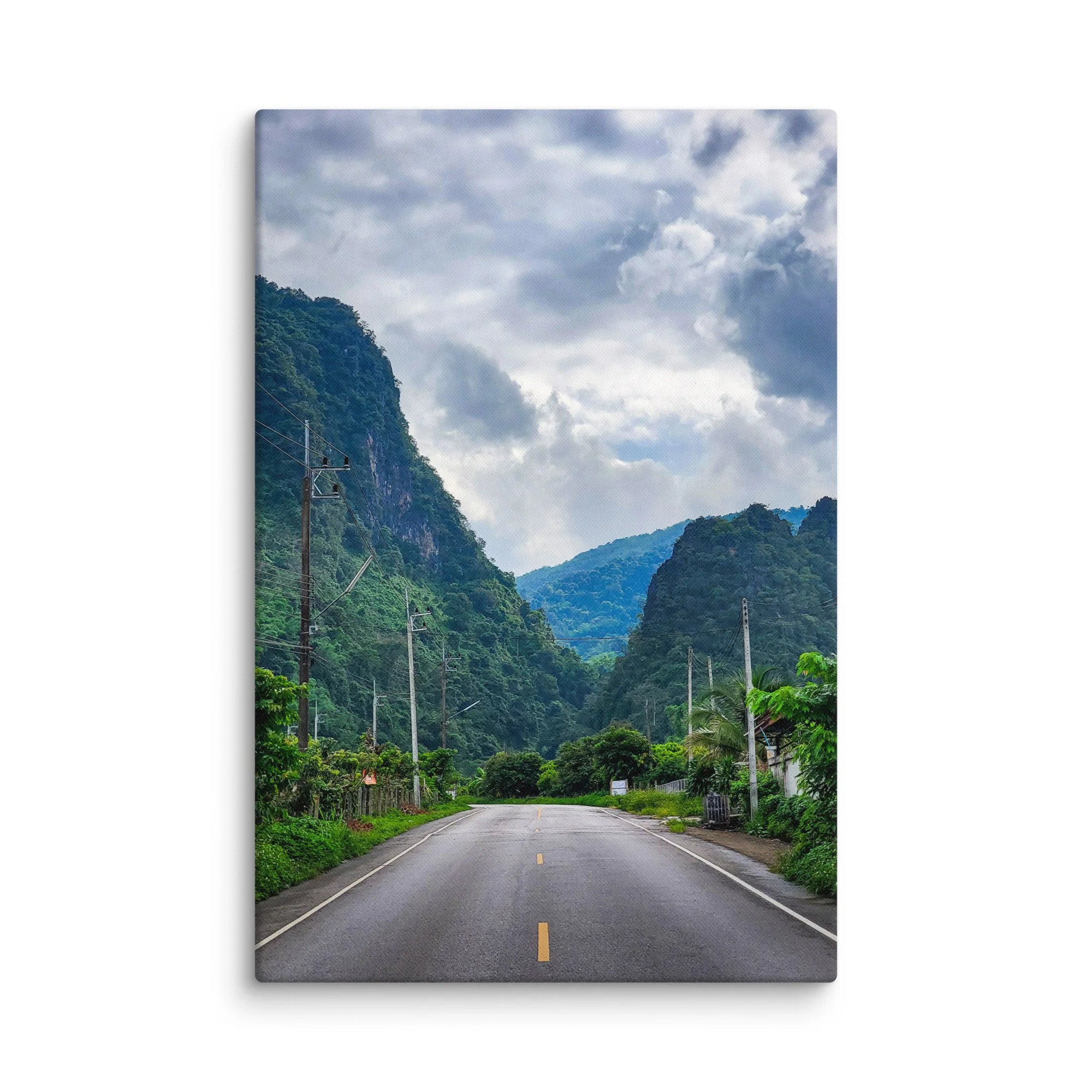 Scenic winding road through lush green karst cliffs and jungle in northern Vietnam (Hà Giang) under dramatic cloudy sky – adventure travel photography canvas print wall art decor