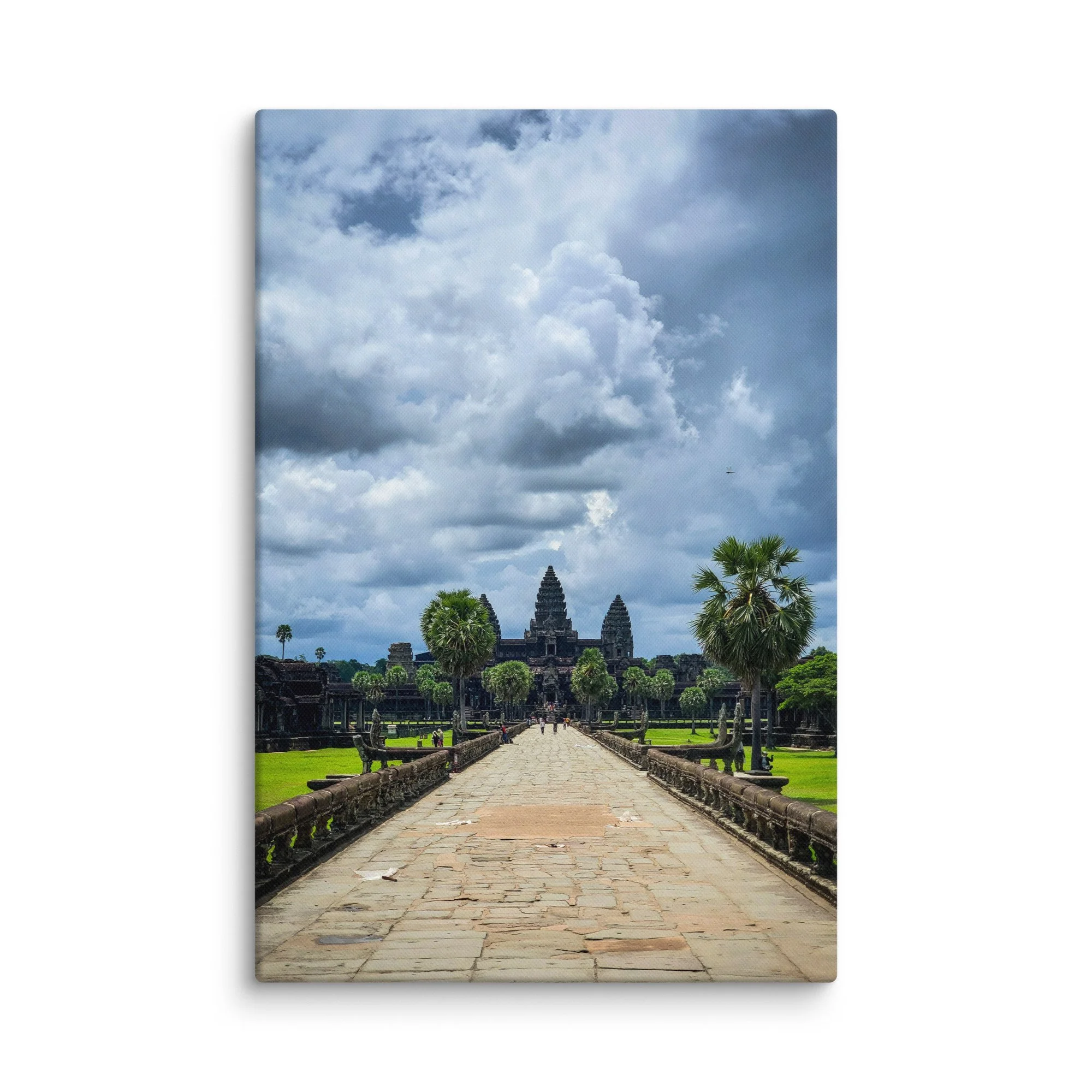 Iconic view along the western causeway toward Angkor Wat temple with towering prangs and dramatic cloudy sky in Siem Reap, Cambodia – historical travel photography canvas print wall art