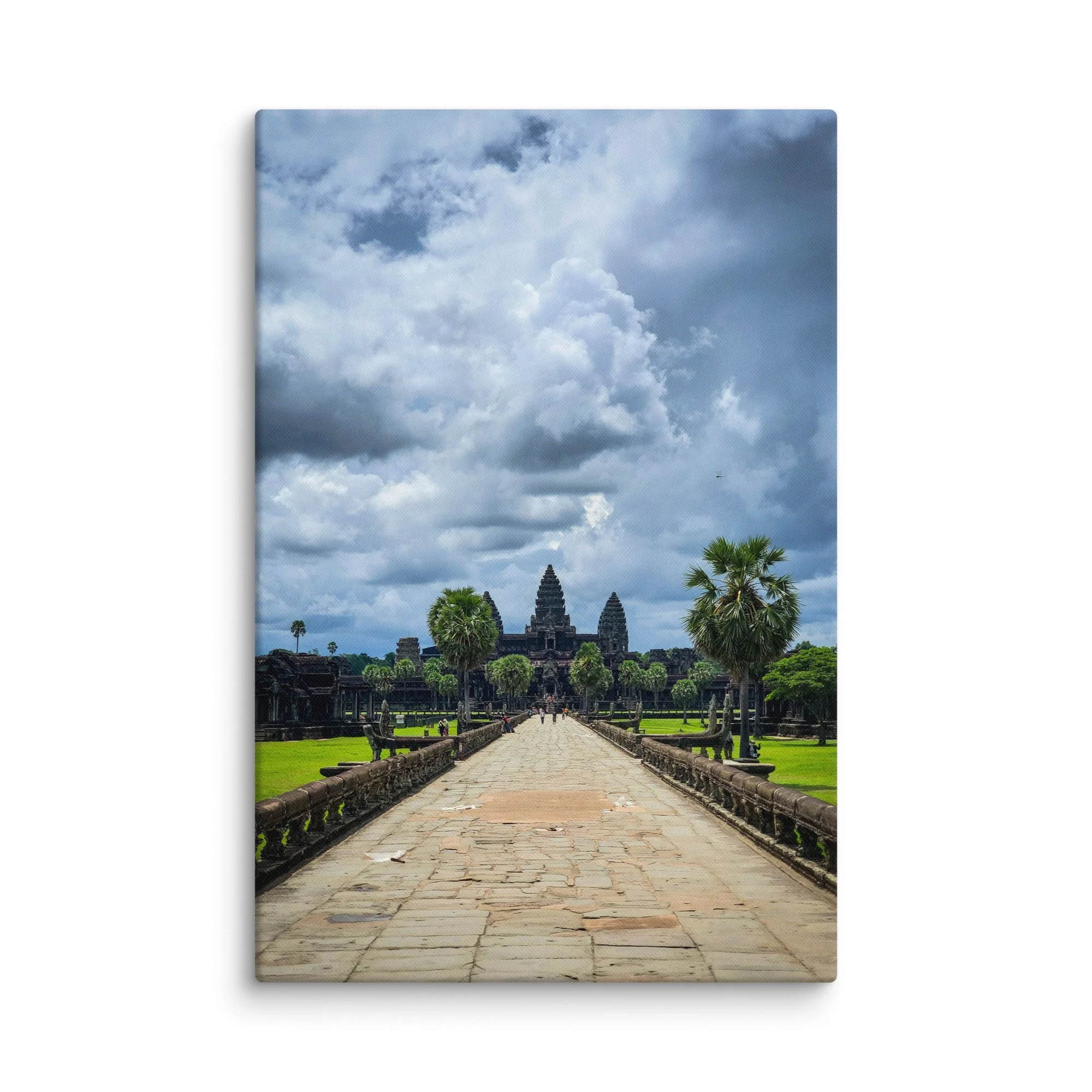 Iconic view along the western causeway toward Angkor Wat temple with towering prangs and dramatic cloudy sky in Siem Reap, Cambodia – historical travel photography canvas print wall art