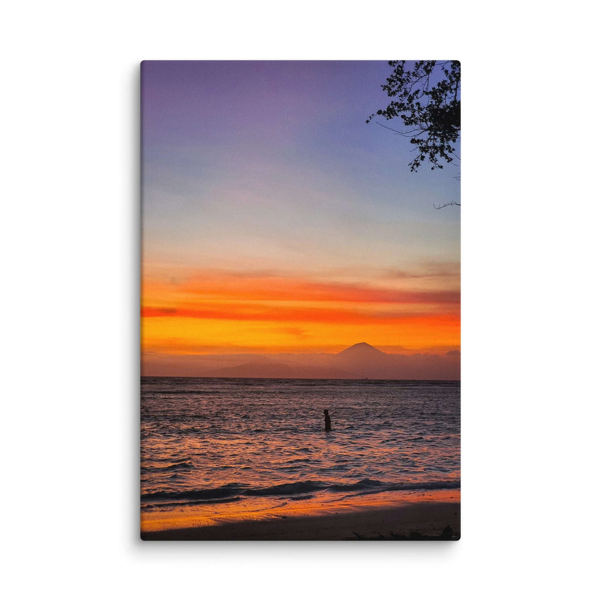 Silhouette of a person standing in the sea at sunset with Mount Rinjani (or Agung) volcano in the background in Indonesia – tropical travel photography canvas print wall art decor