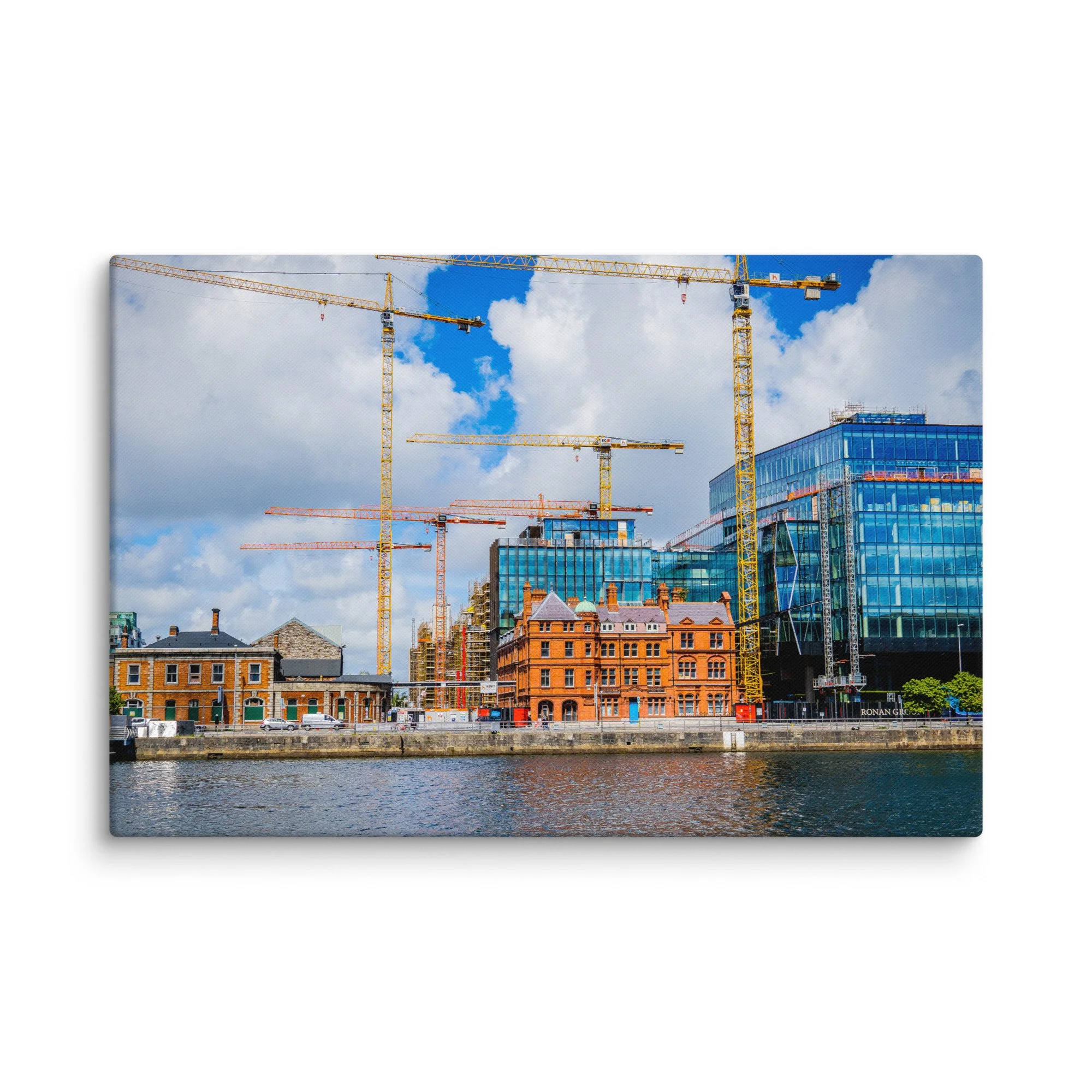 Vibrant view of Dublin’s Grand Canal Dock with yellow cranes, modern glass buildings, historic warehouses and calm water under blue sky – Irish urban travel photography canvas print