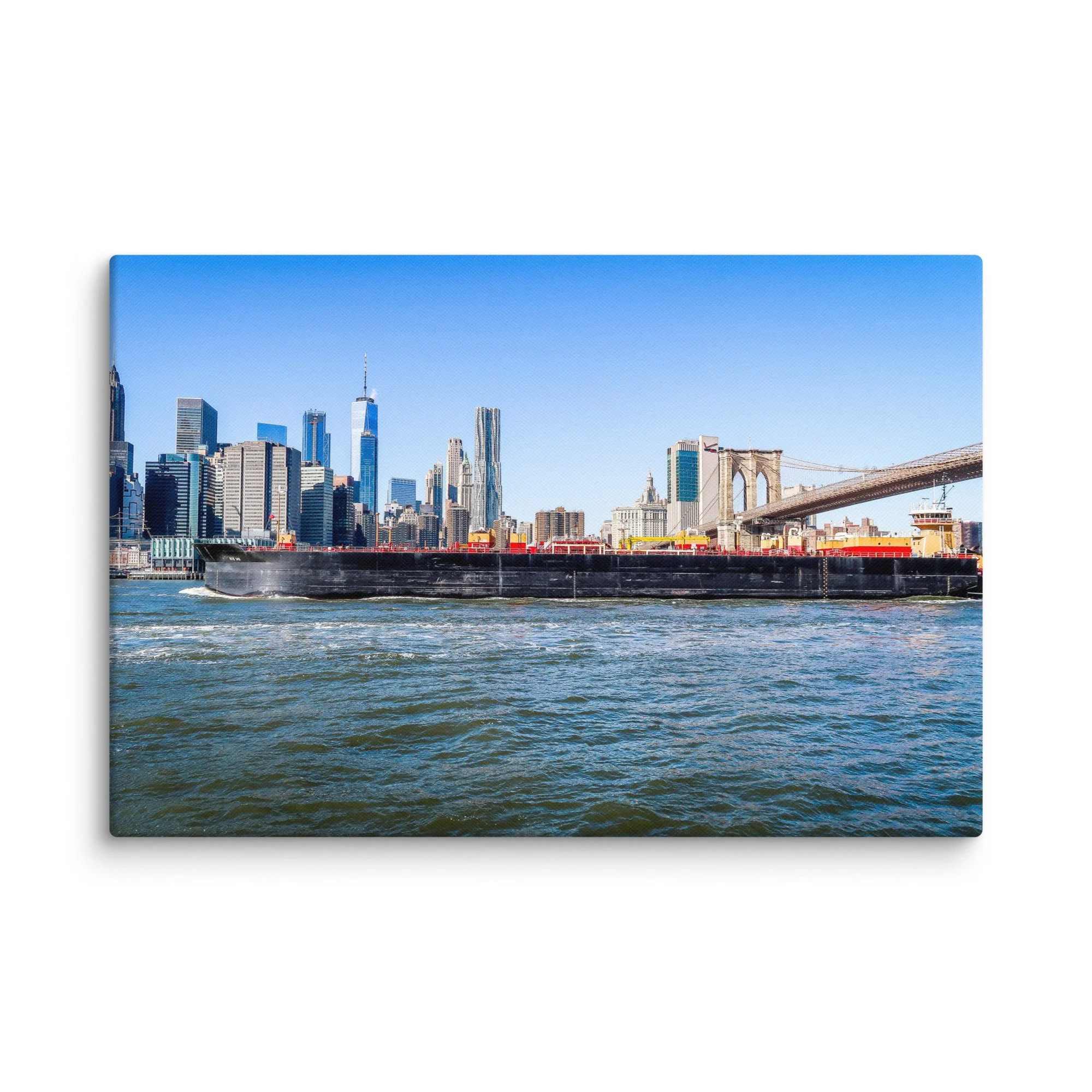 Panoramic view of Brooklyn Bridge, Manhattan skyline and large cargo barge on East River in New York City under bright blue sky – urban travel photography canvas print wall art decor