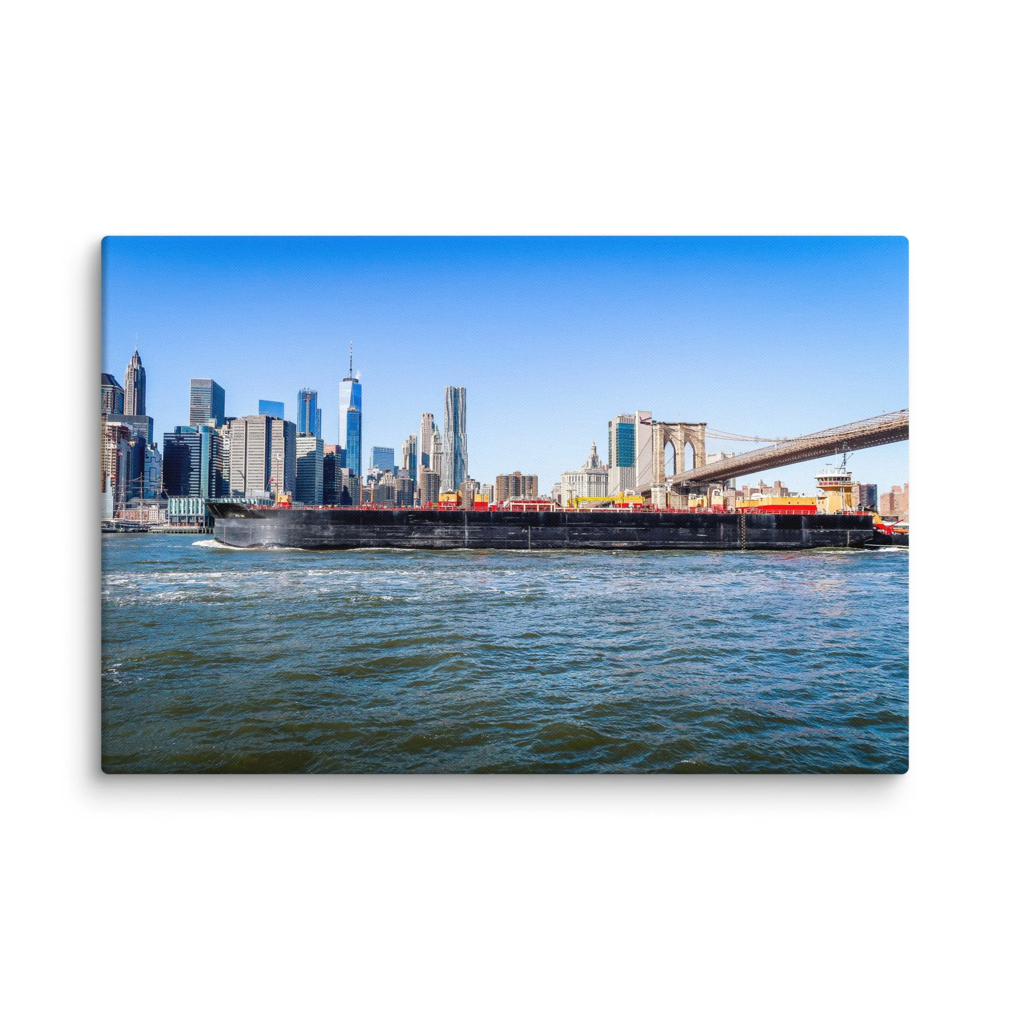 Panoramic view of Brooklyn Bridge, Manhattan skyline and large cargo barge on East River in New York City under bright blue sky – urban travel photography canvas print wall art decor