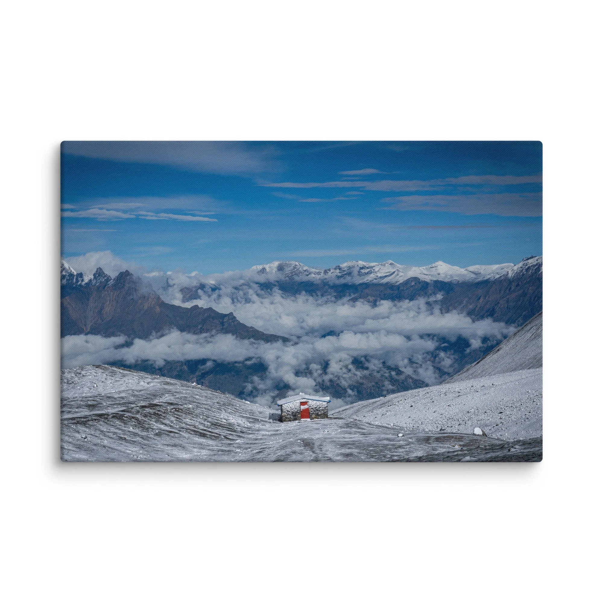 Trekker in red jacket standing on snowy ridge at Thorong La Pass on the Annapurna Circuit, Nepal, overlooking dramatic Himalayan peaks and sea of clouds – high-altitude trekking travel