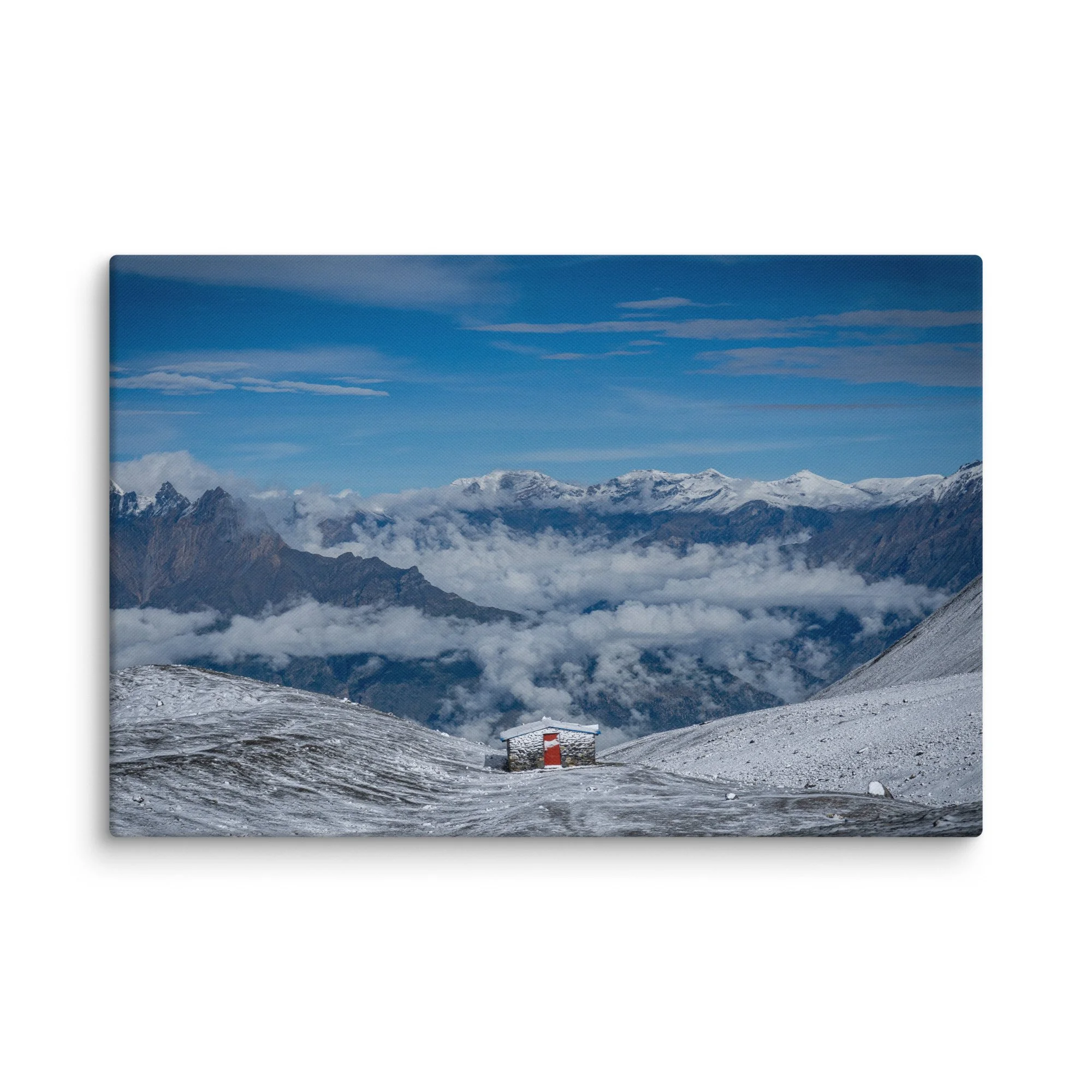 Trekker in red jacket standing on snowy ridge at Thorong La Pass on the Annapurna Circuit, Nepal, overlooking dramatic Himalayan peaks and sea of clouds – high-altitude trekking travel