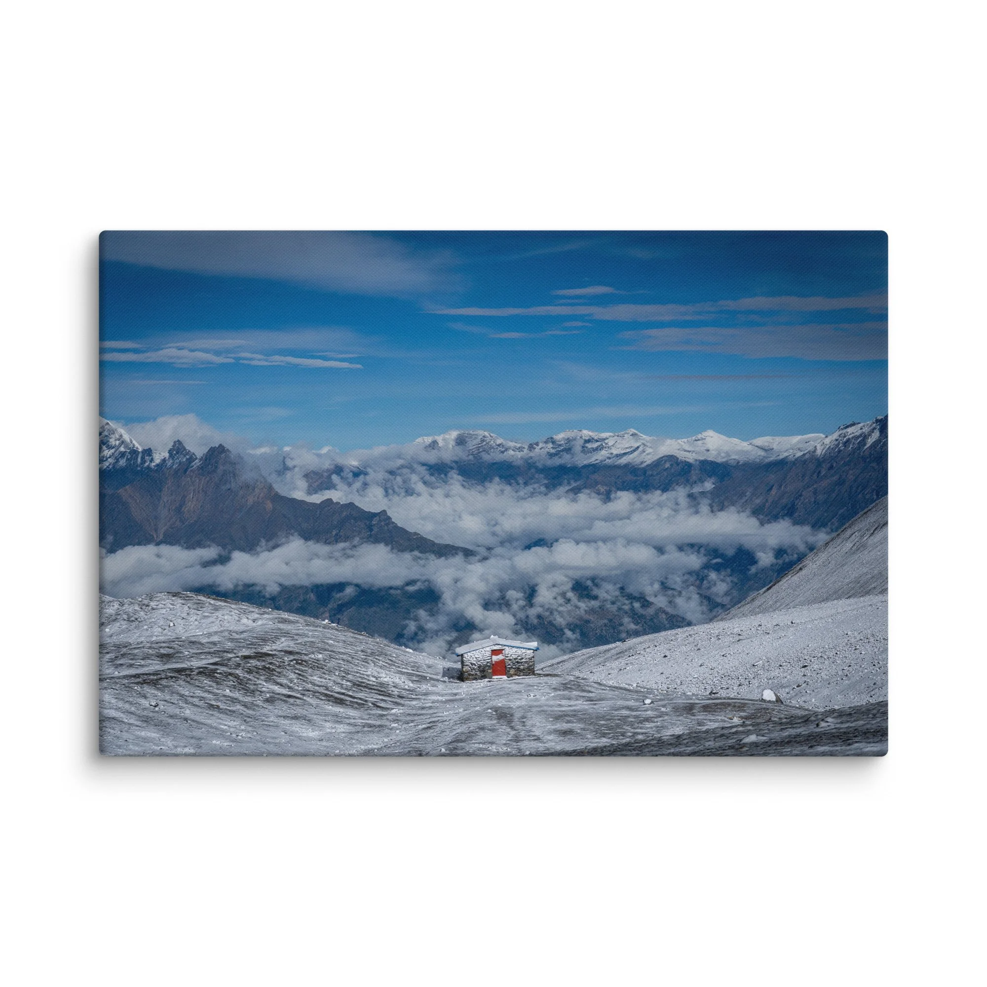 Trekker in red jacket standing on snowy ridge at Thorong La Pass on the Annapurna Circuit, Nepal, overlooking dramatic Himalayan peaks and sea of clouds – high-altitude trekking travel