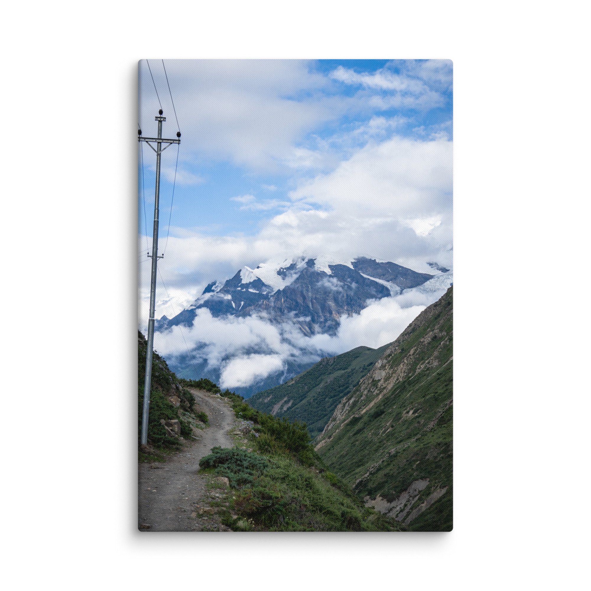 Winding mountain trail on the Annapurna Circuit, Nepal with lush greenery and towering snow-capped Himalayan peaks under blue sky – high-altitude trekking travel photography canvas