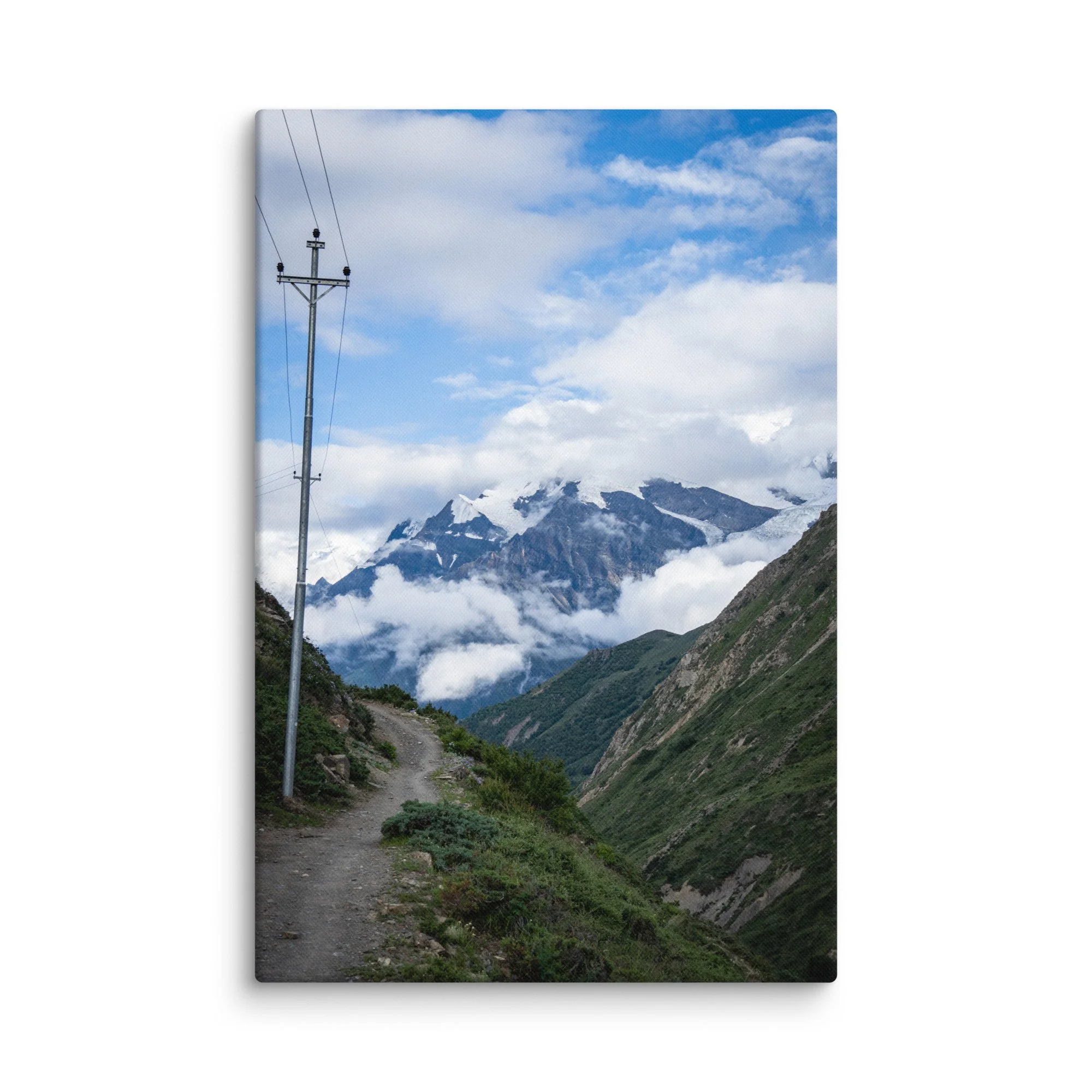 Winding mountain trail on the Annapurna Circuit, Nepal with lush greenery and towering snow-capped Himalayan peaks under blue sky – high-altitude trekking travel photography canvas