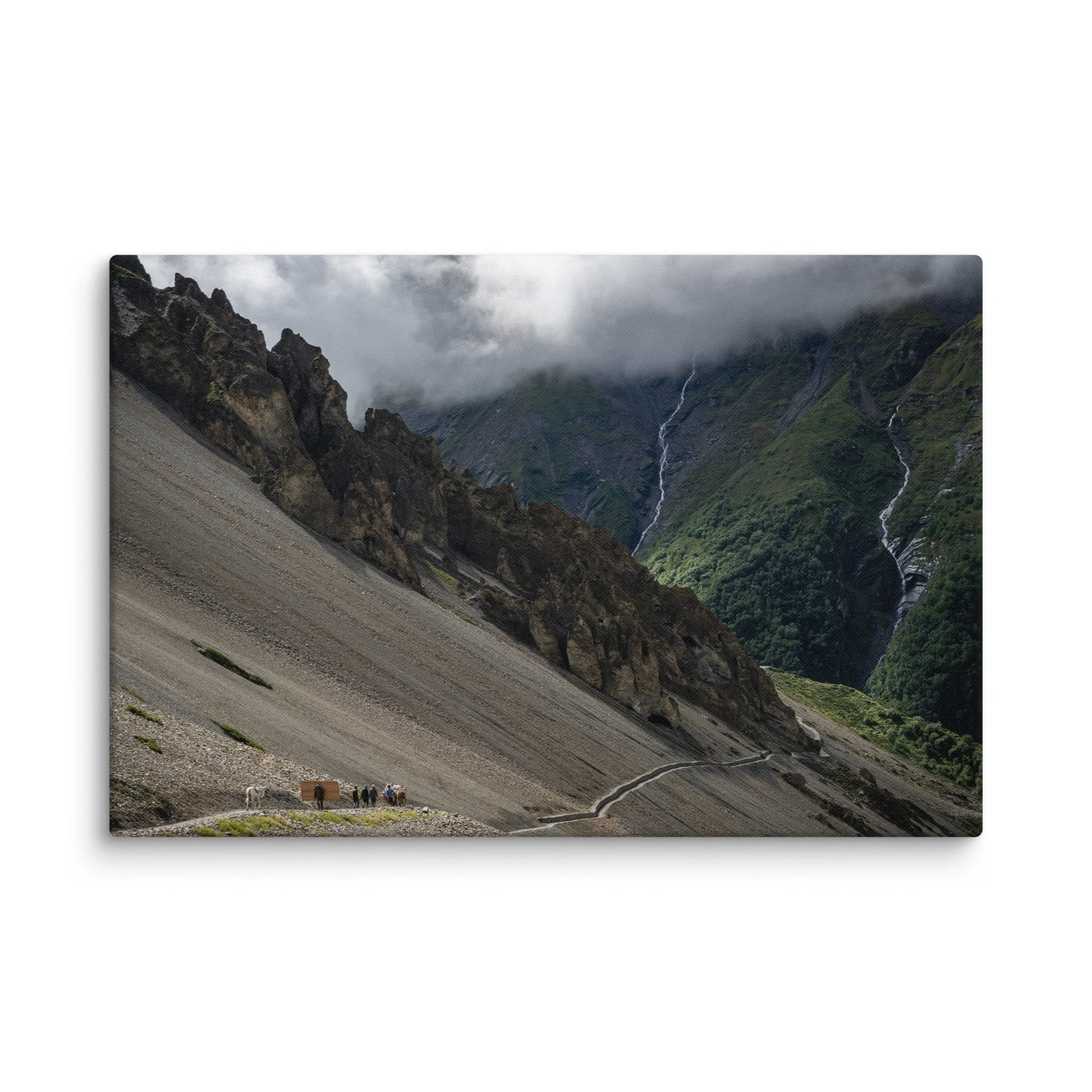 Trekkers with mules descending a steep rocky trail on the Annapurna Circuit, Nepal, with dramatic Himalayan peaks, waterfalls and moody sky – high-altitude trekking travel photography