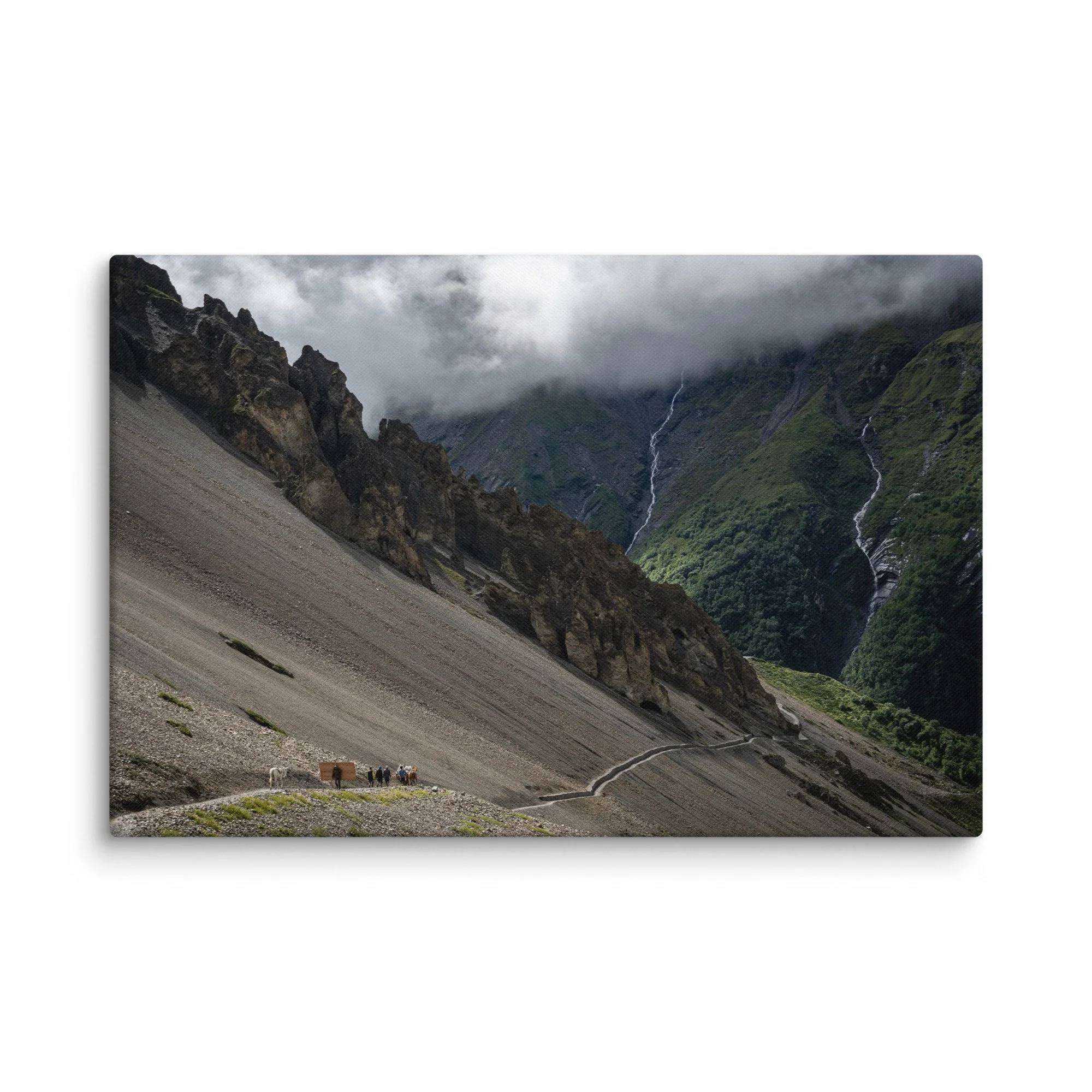 Trekkers with mules descending a steep rocky trail on the Annapurna Circuit, Nepal, with dramatic Himalayan peaks, waterfalls and moody sky – high-altitude trekking travel photography