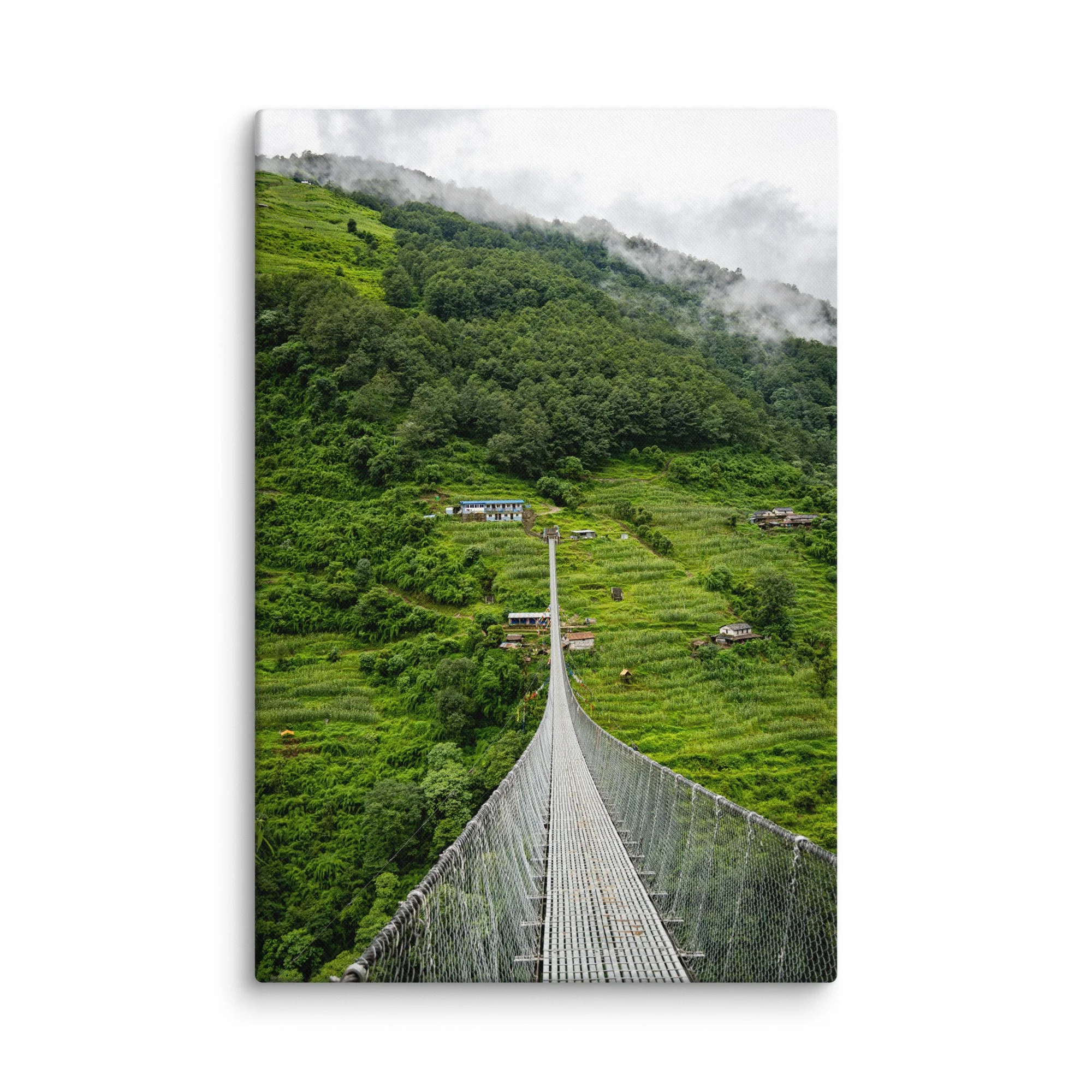 Long suspension bridge crossing a lush green valley on the Annapurna Circuit, Nepal with misty hills, villages and Himalayan peaks – high-altitude trekking travel photography canvas print