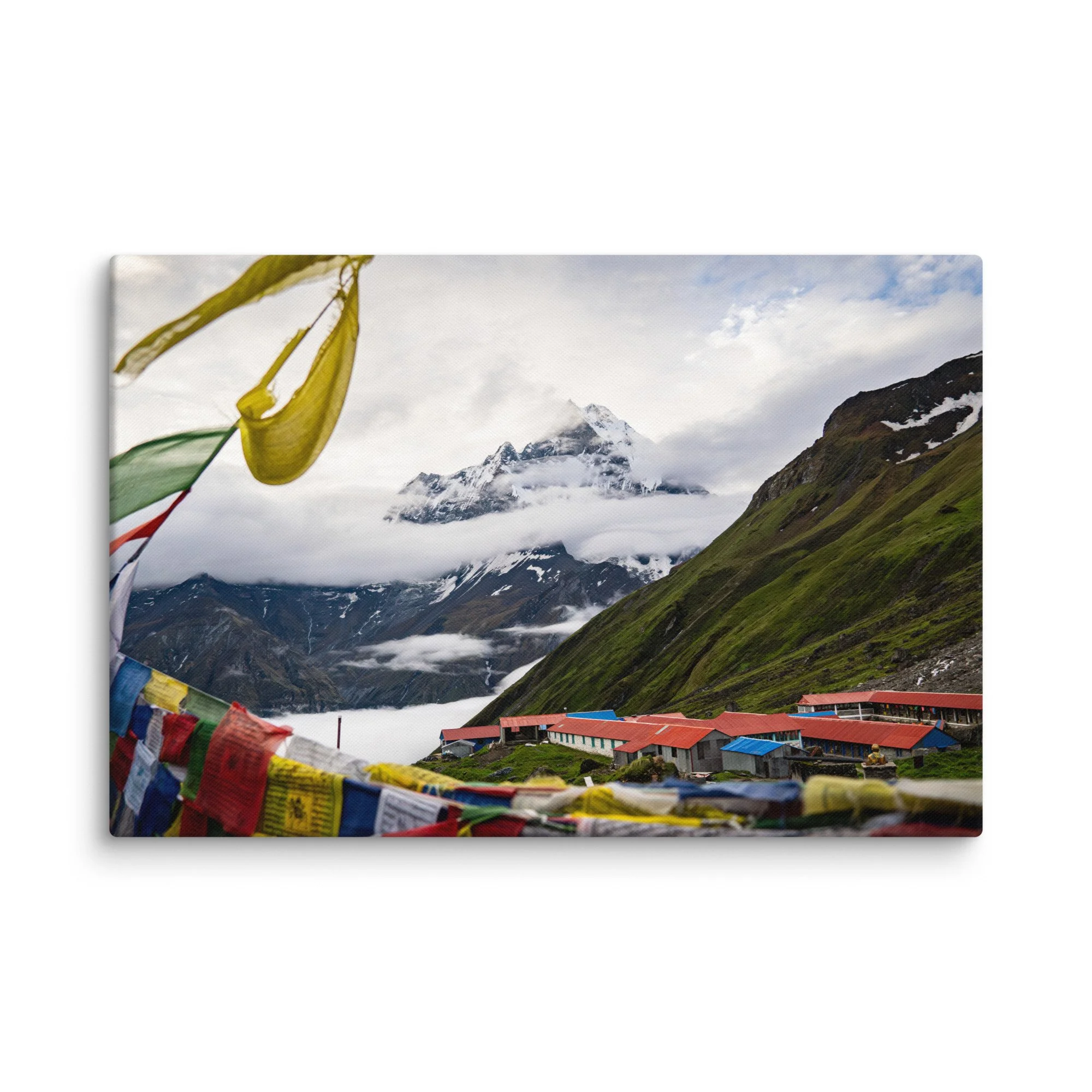 Vibrant multicolored prayer flags in the foreground with towering snow-covered Himalayan peaks and misty sky on the Annapurna Circuit, Nepal – high-altitude spiritual trekking travel