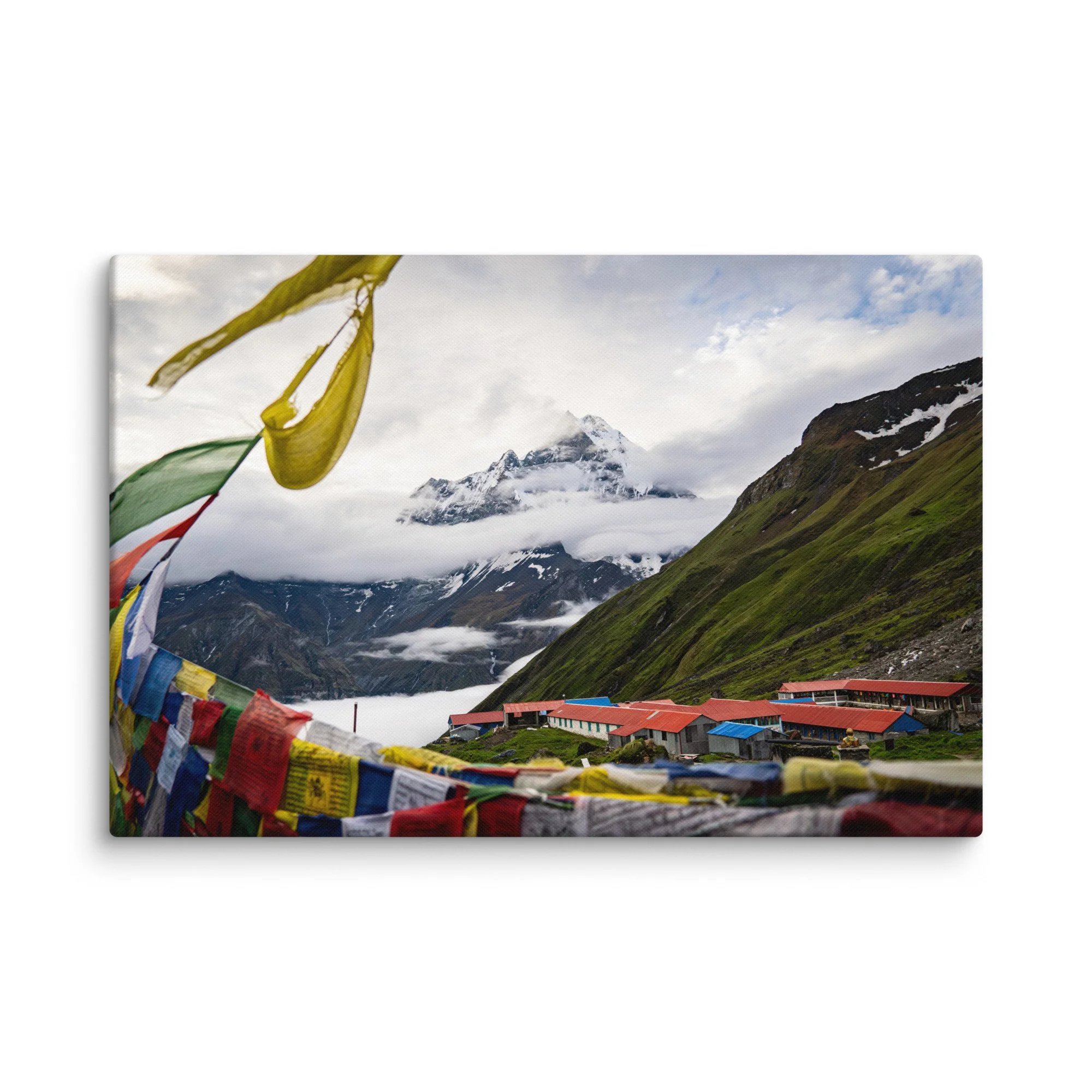 Vibrant multicolored prayer flags in the foreground with towering snow-covered Himalayan peaks and misty sky on the Annapurna Circuit, Nepal – high-altitude spiritual trekking travel
