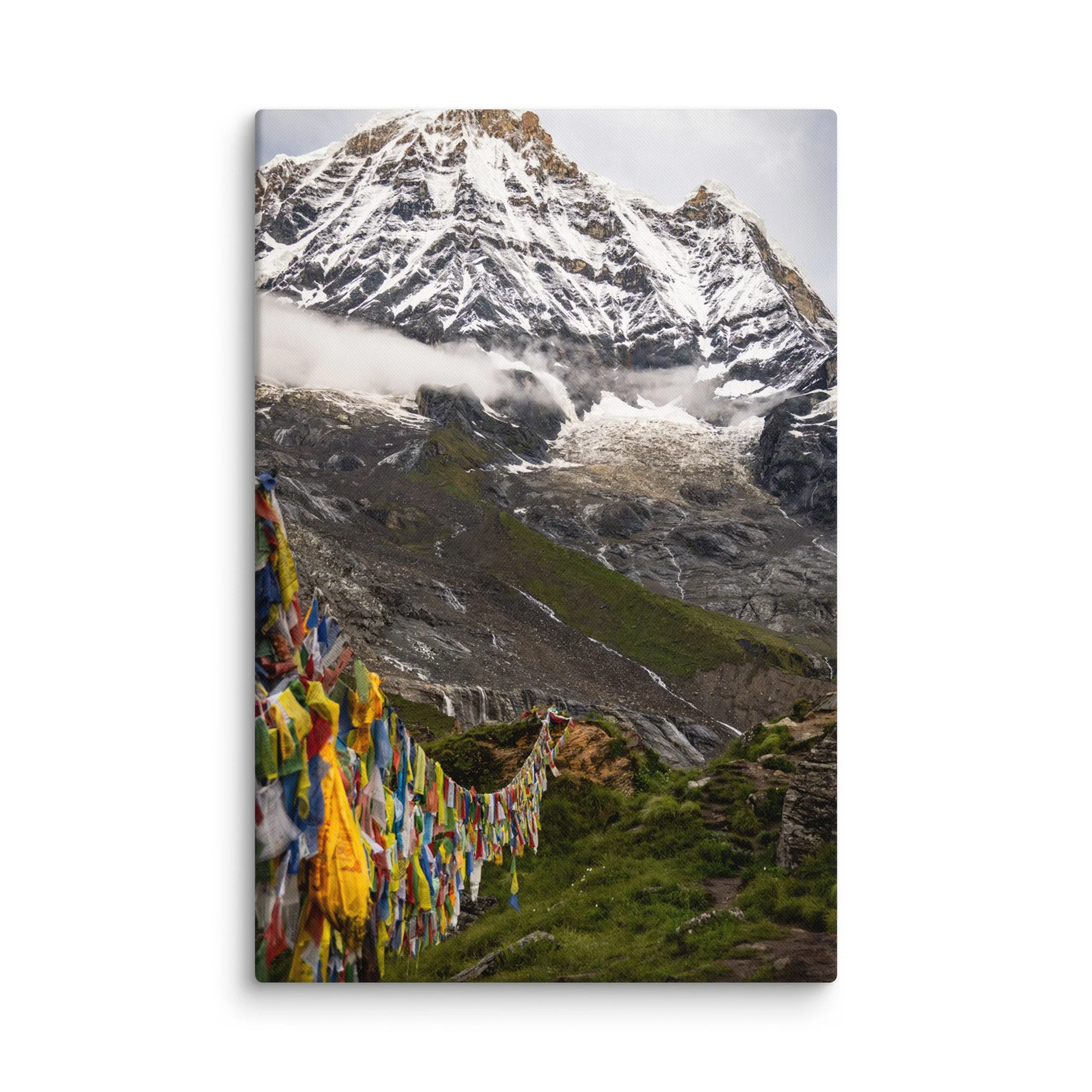 Vibrant multicolored prayer flags fluttering in the foreground with towering snow-covered Himalayan peaks and misty sky at Annapurna Base Camp, Nepal – high-altitude spiritual trekking