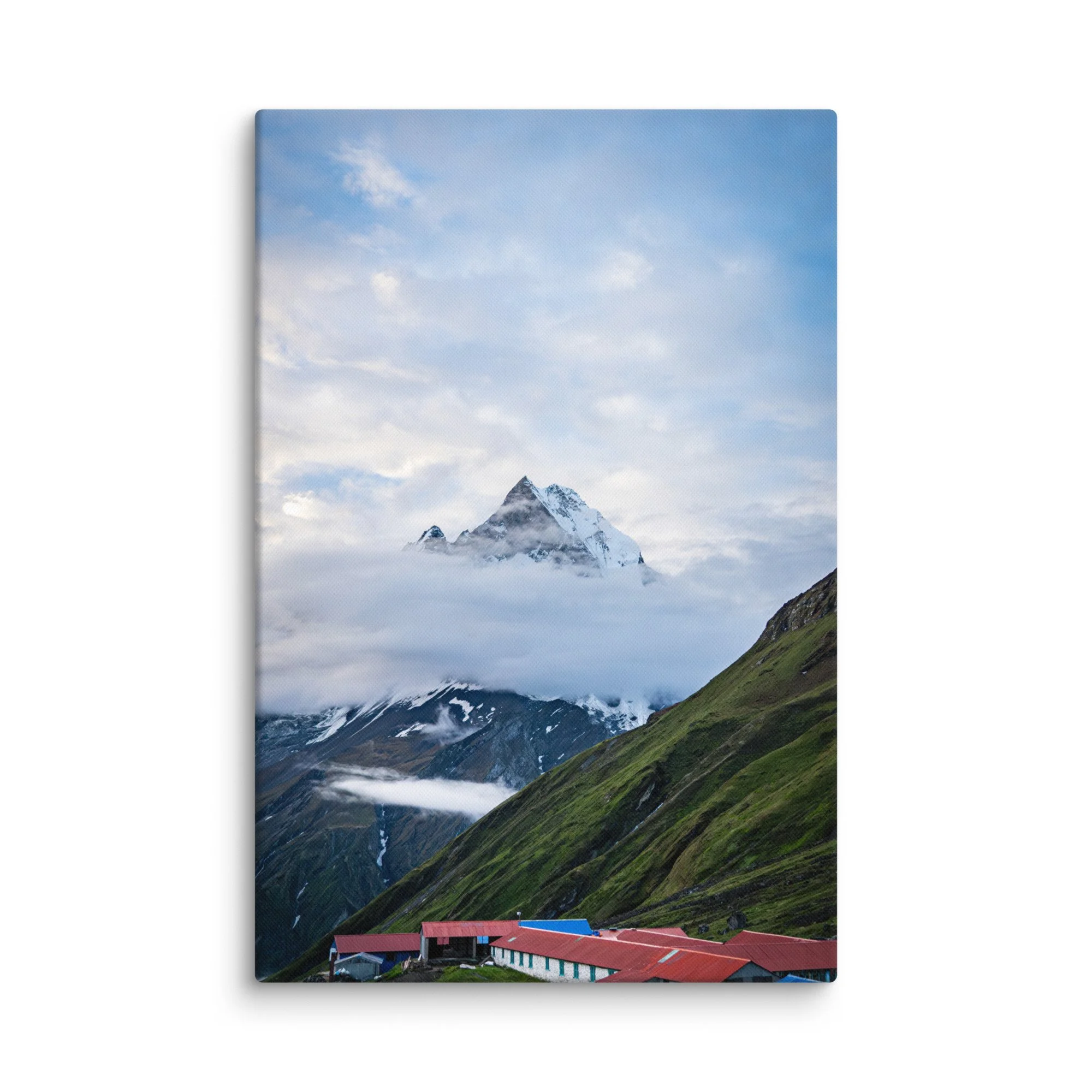 Colorful teahouses and lodges with red and blue roofs nestled in the green slopes below towering snow-covered Himalayan peaks at Annapurna Base Camp, Nepal – high-altitude trekking