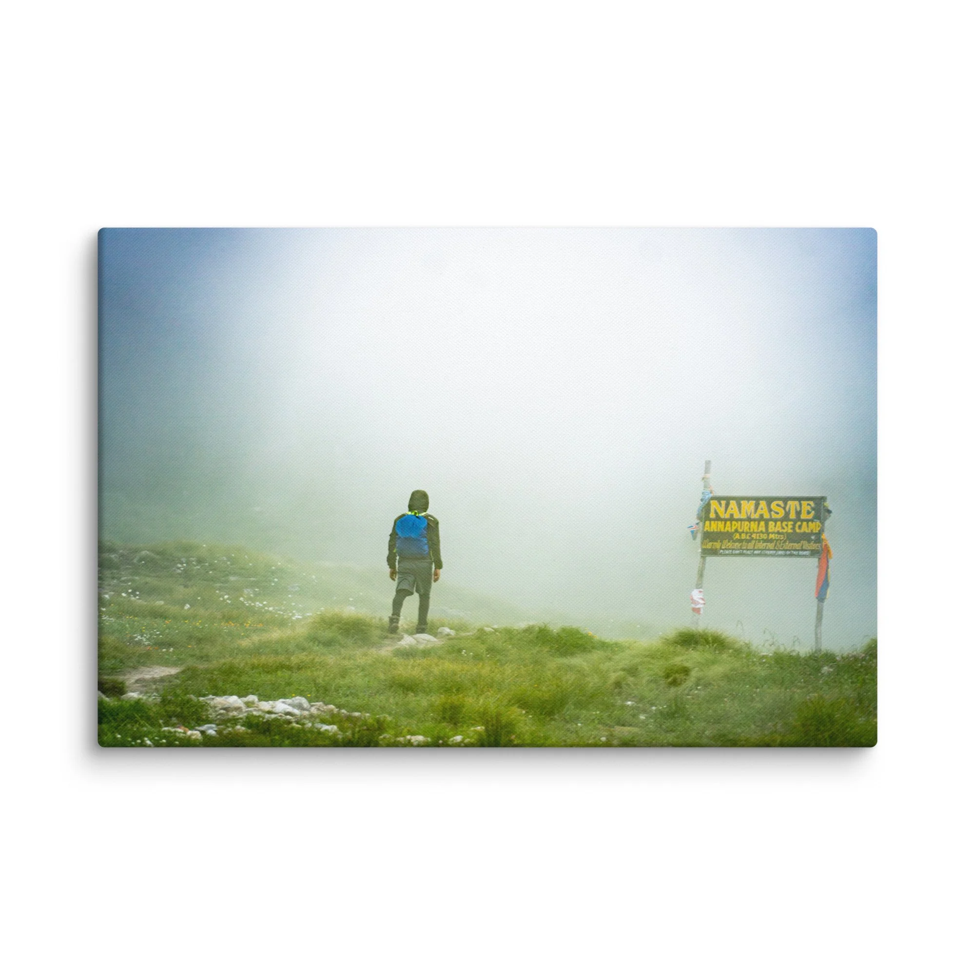 Trekker standing at the famous Namaste Annapurna Base Camp signpost in misty alpine terrain, Nepal – high-altitude trekking travel photography canvas print wall art decor