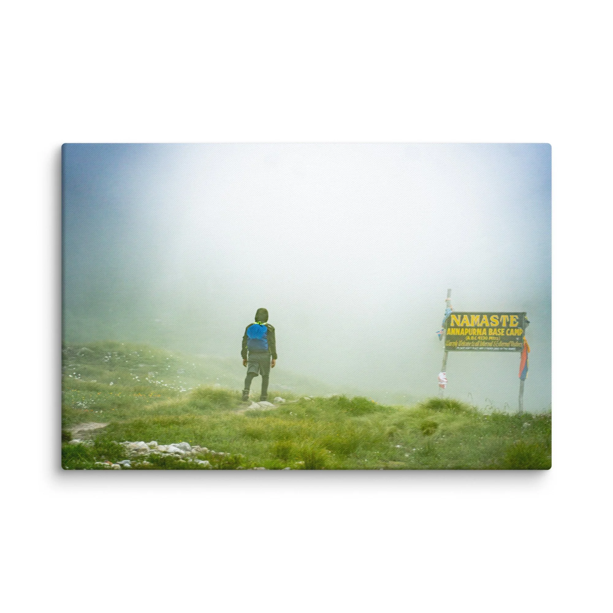 Trekker standing at the famous Namaste Annapurna Base Camp signpost in misty alpine terrain, Nepal – high-altitude trekking travel photography canvas print wall art decor